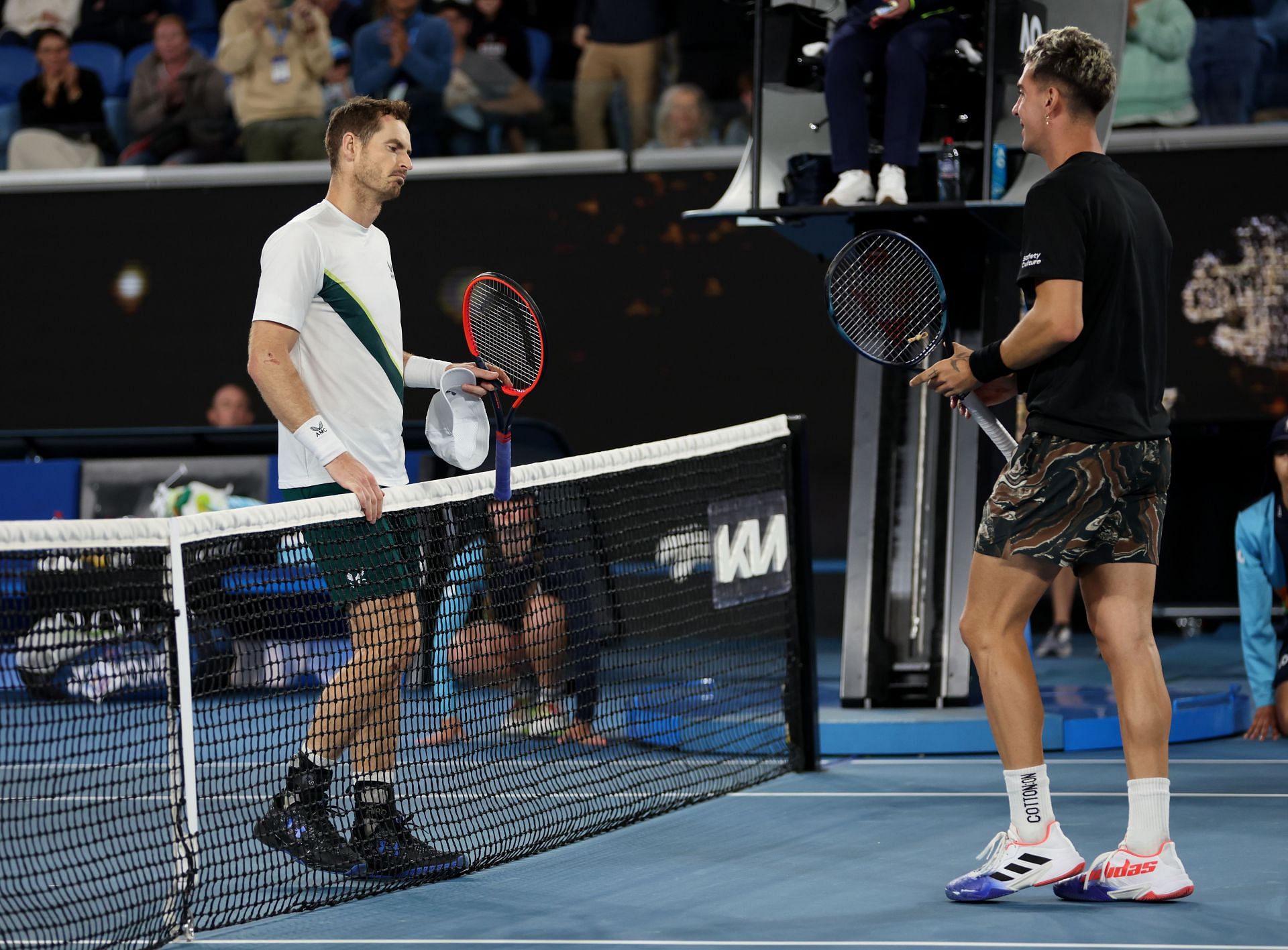 Andy Murray (left) and Thanasi Kokkinakis meet at the net.