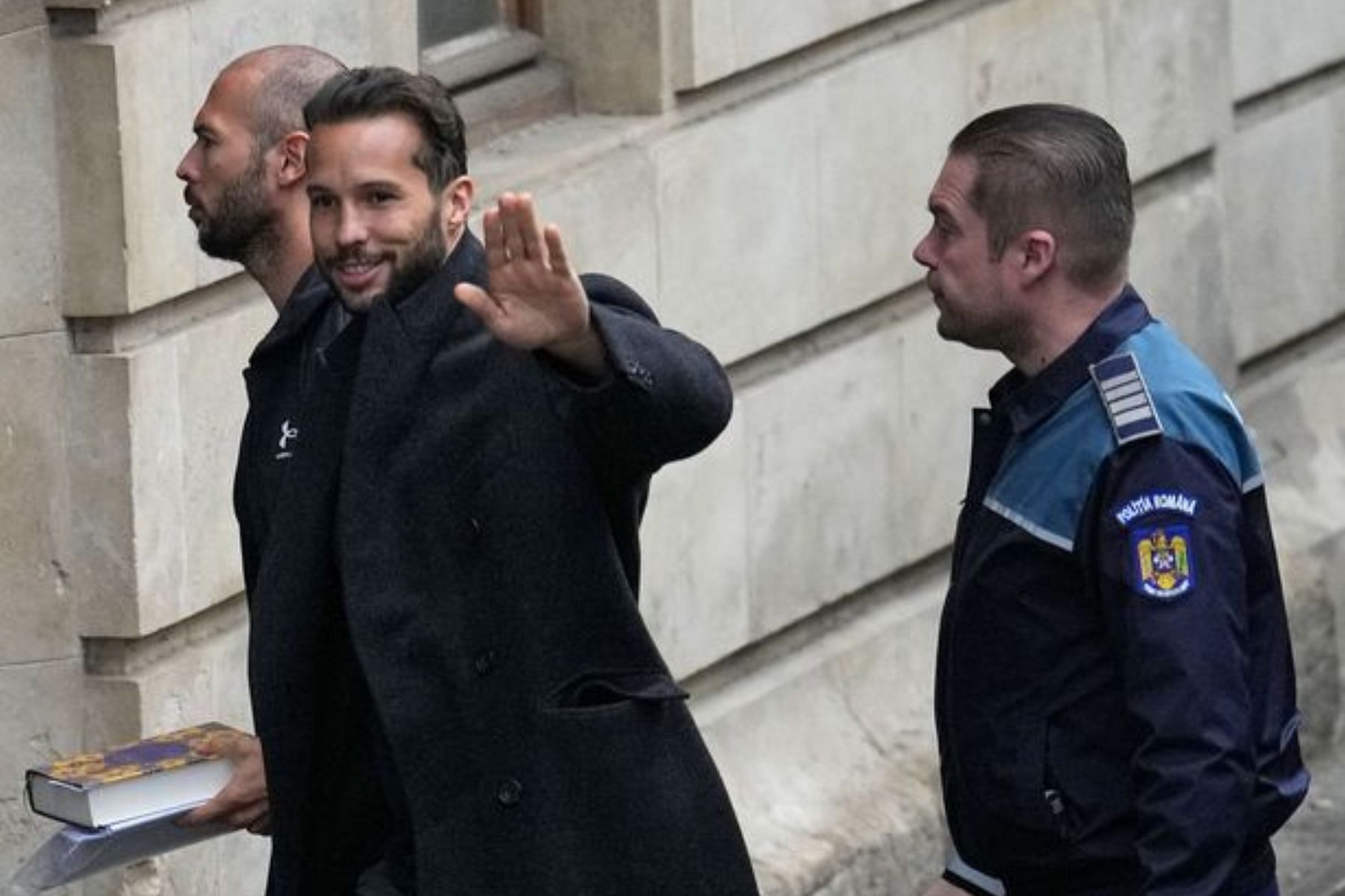 Tristan Tate waved to the group of supportes who assembled outside the appeals court on Tuesday. (Image via Vadim Ghirda/AP)