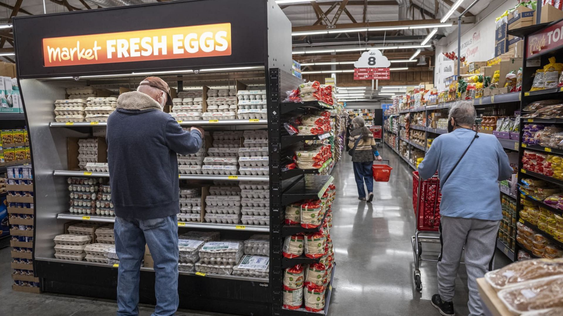 a customer picks eggs from an aisle at a Market Fresh grocery store amidst the nationwide increase in egg prices (Image via David Paul Morris/Bloomberg/Getty Images)