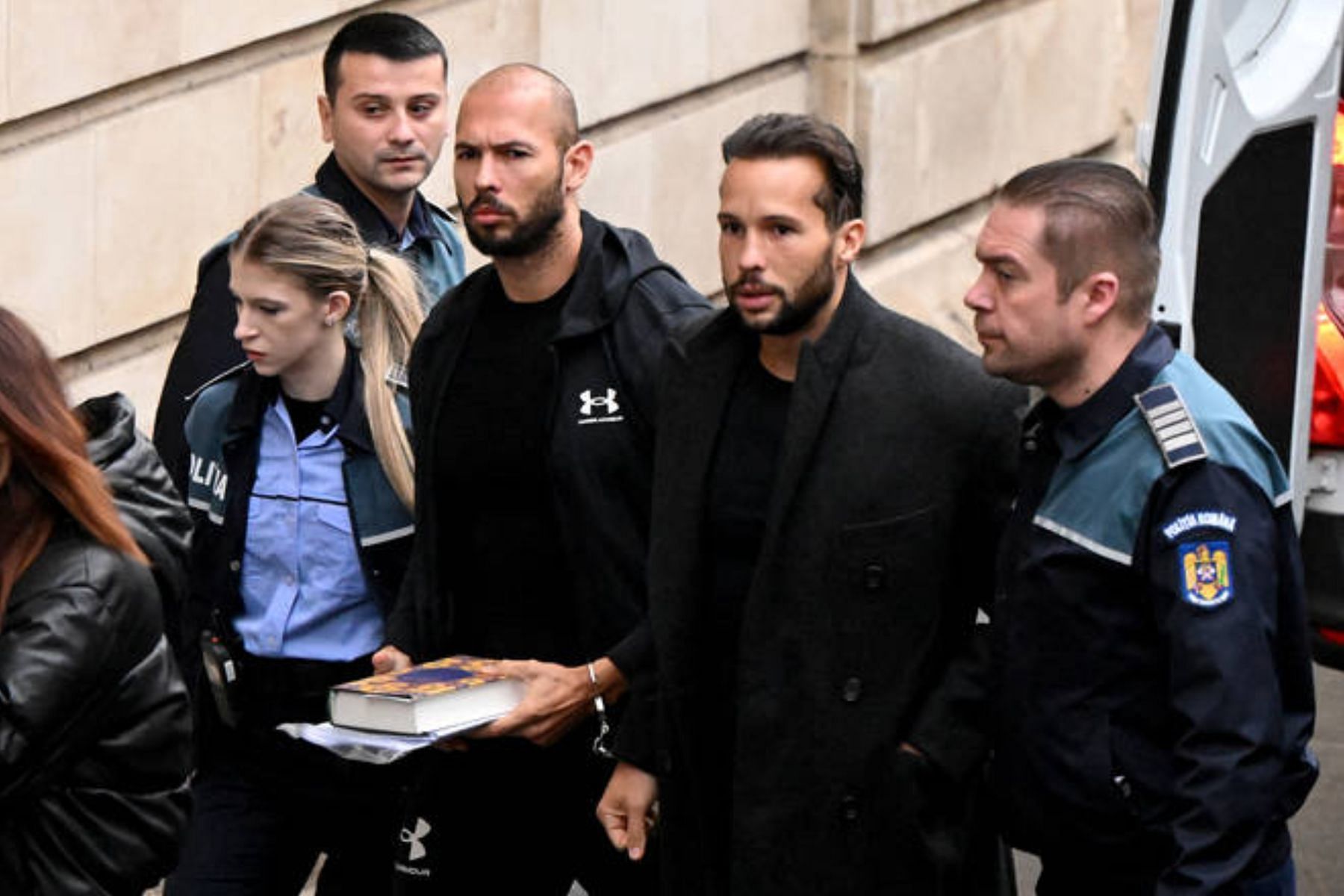 The Tate brothers on their way to the hearing on Tuesday. (Image via Vadim Ghirda/AP)