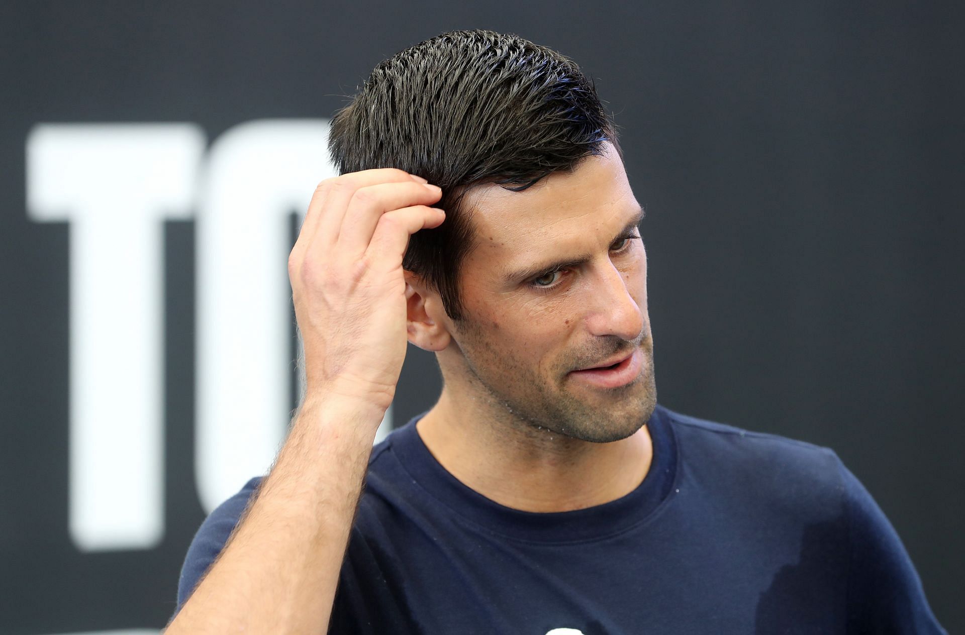 Novak Djokovic talks to the media after a practice session
