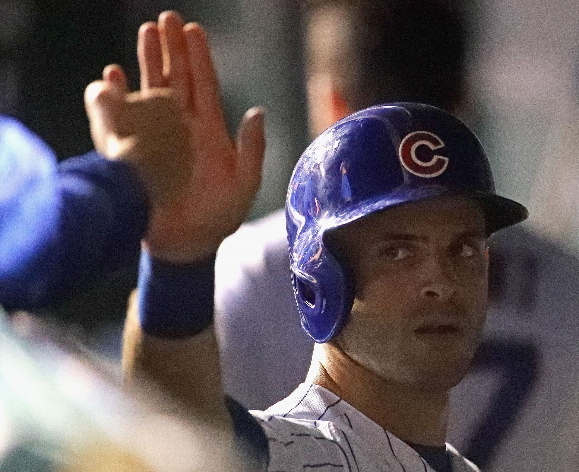 Tommy La Stella of the Chicago Cubs is congratulated in the dugout after scoring a run.
