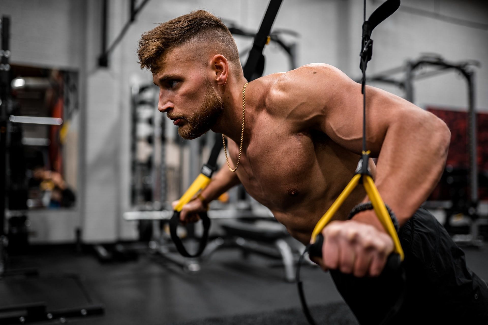 TRX chest presses (Photo via Unsplash/Anastase Maragos)