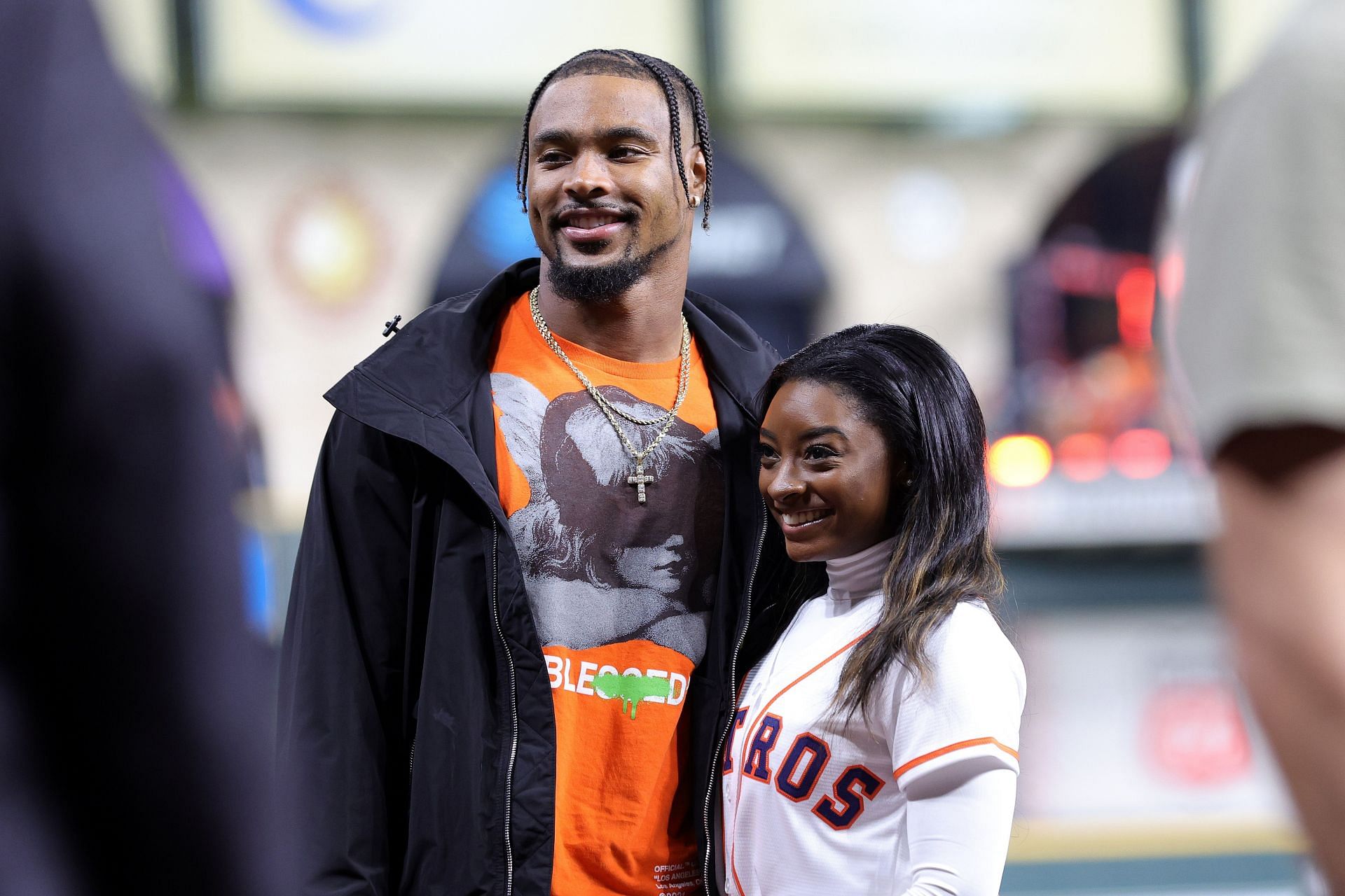 Simone Biles and Jonathan Owens pose on the field prior to Game One of the 2022 World Series 