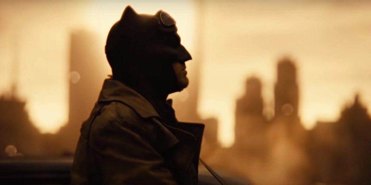 Batman, in his iconic armored suit, stands amidst a post-apocalyptic wasteland in the Knightmare vision (Image via Warner Bros)