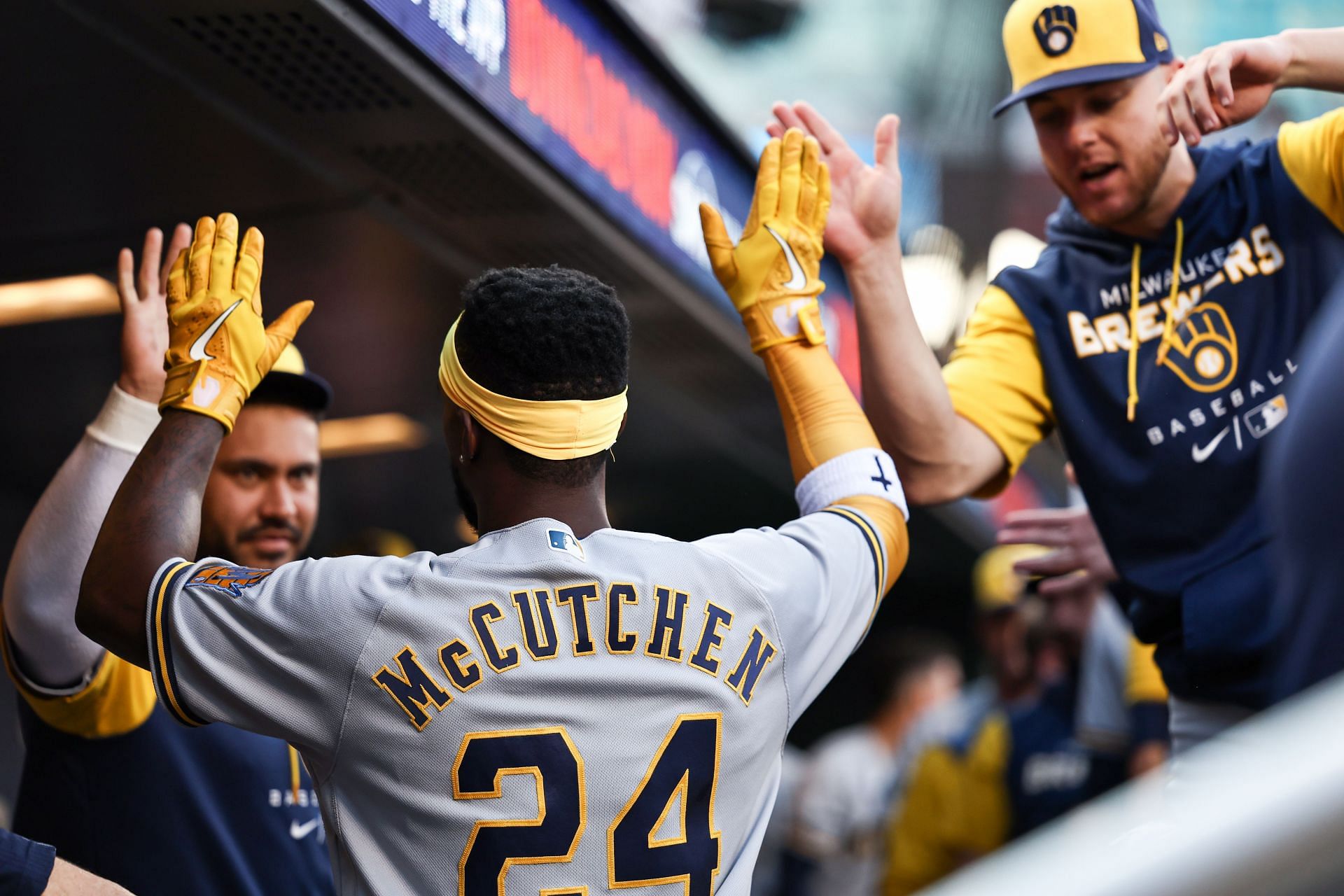 Andrew McCutchen is greeted by teammates in the dugout after scoring a run at Citi Field