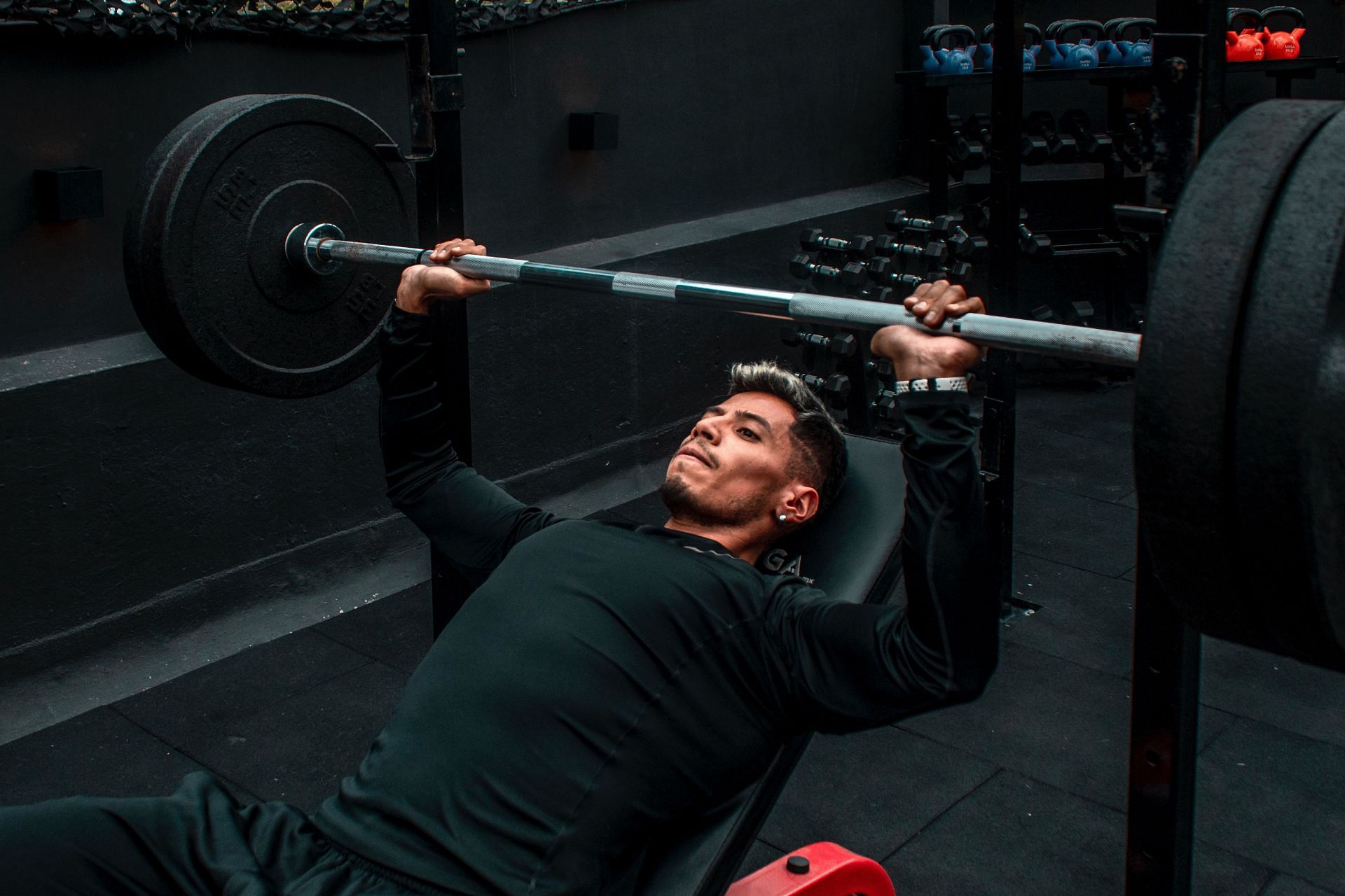 Skull crusher workout can be performed with a barbell also. (Image via Pexels/ Cesar Perez)