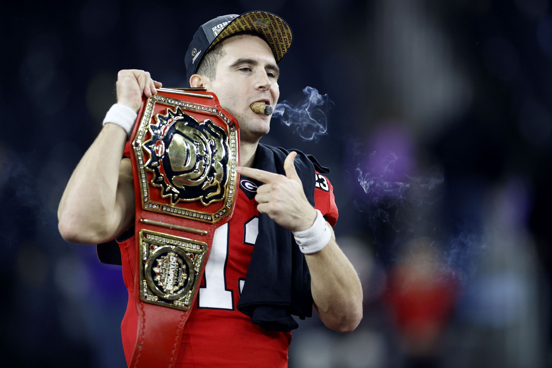 INGLEWOOD, CALIFORNIA - JANUARY 09: Stetson Bennett #13 of the Georgia Bulldogs celebrates with teammates and a cigar after defeating the TCU Horned Frogs in the College Football Playoff National Championship game at SoFi Stadium on January 09, 2023 in Inglewood, California. Georgia defeated TCU 65-7. (Photo by Steph Chambers/Getty Images)