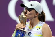 Iga Swiatek kisses the trophy at the Qatar Total Energies Open
