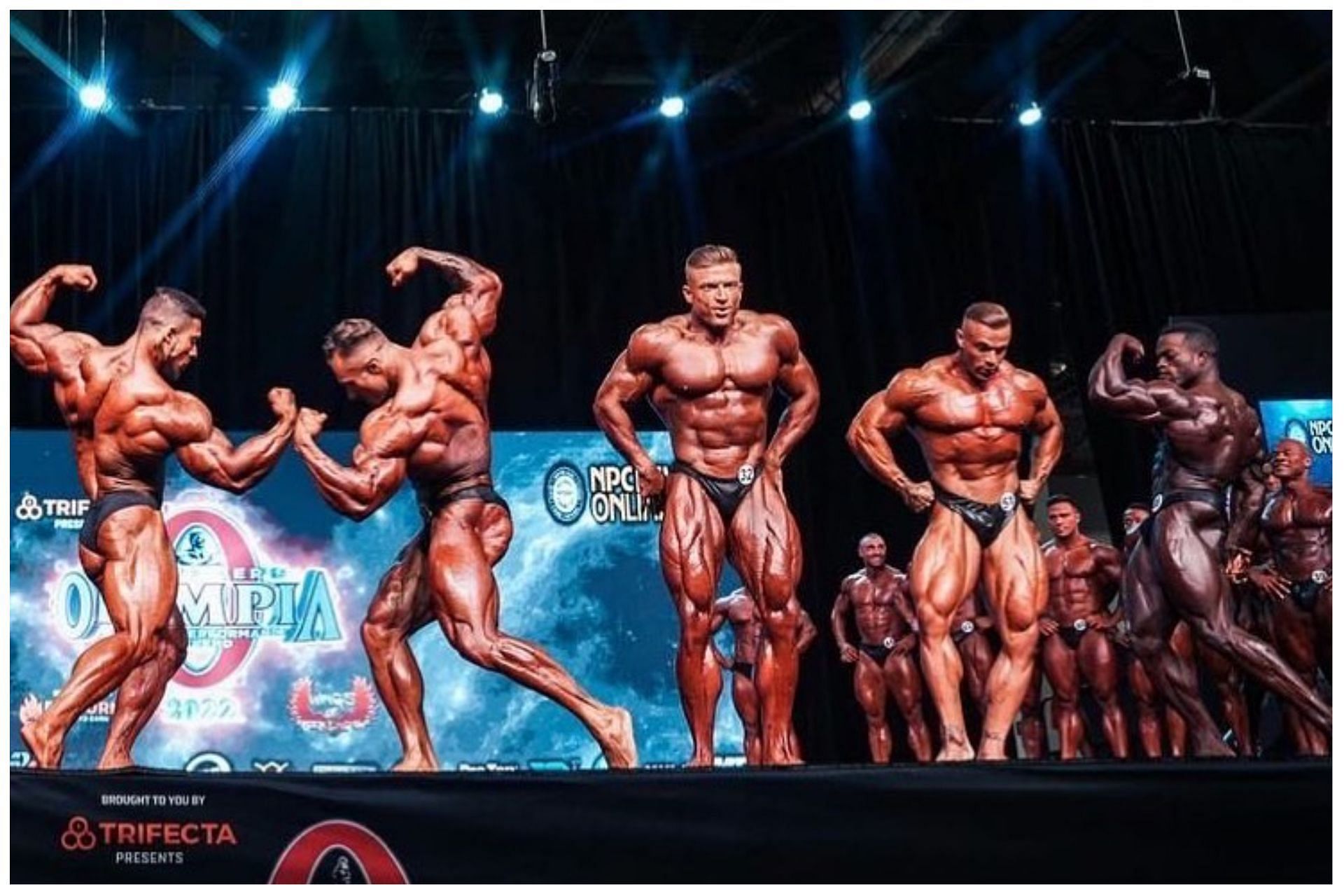 (L-R) Ramon Dino, Chris Bumstead and Urs Kalecinski pose on stage at the 2022 Mr. Olympia: Image via Instagram (@mrolympiallc)