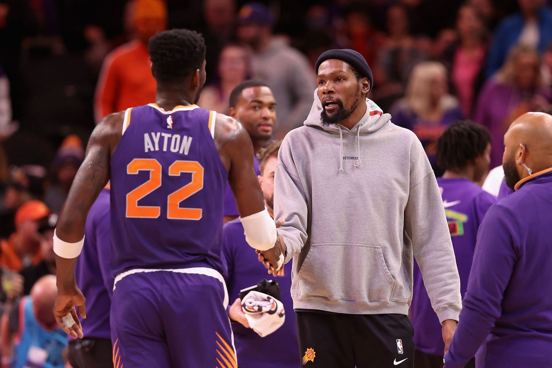 Kevin Durant (right) greets Deandre Ayton and other Phoenix Suns teammates