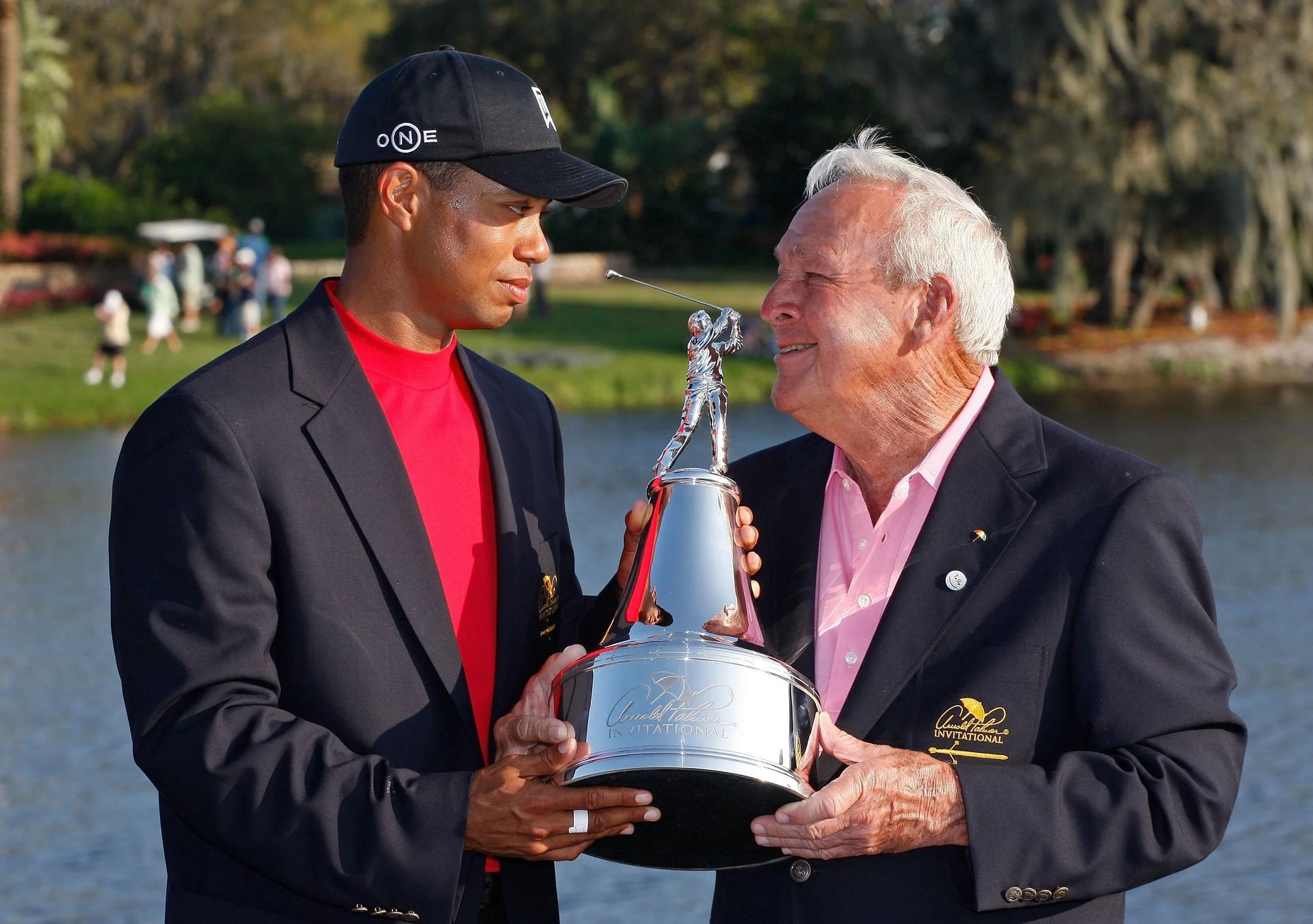 Tiger Woods receiving the API trophy from Arnold Palmer