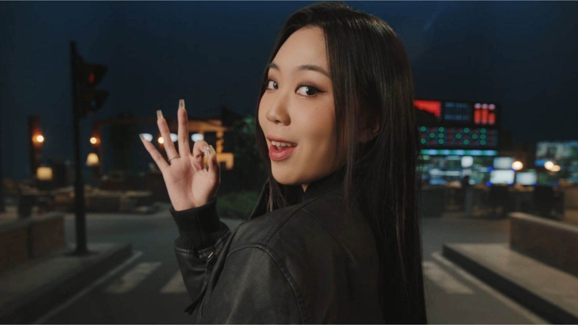 Korean rapper Lee Young-ji with her back to the camera, turns and smirks in the music video for BSS