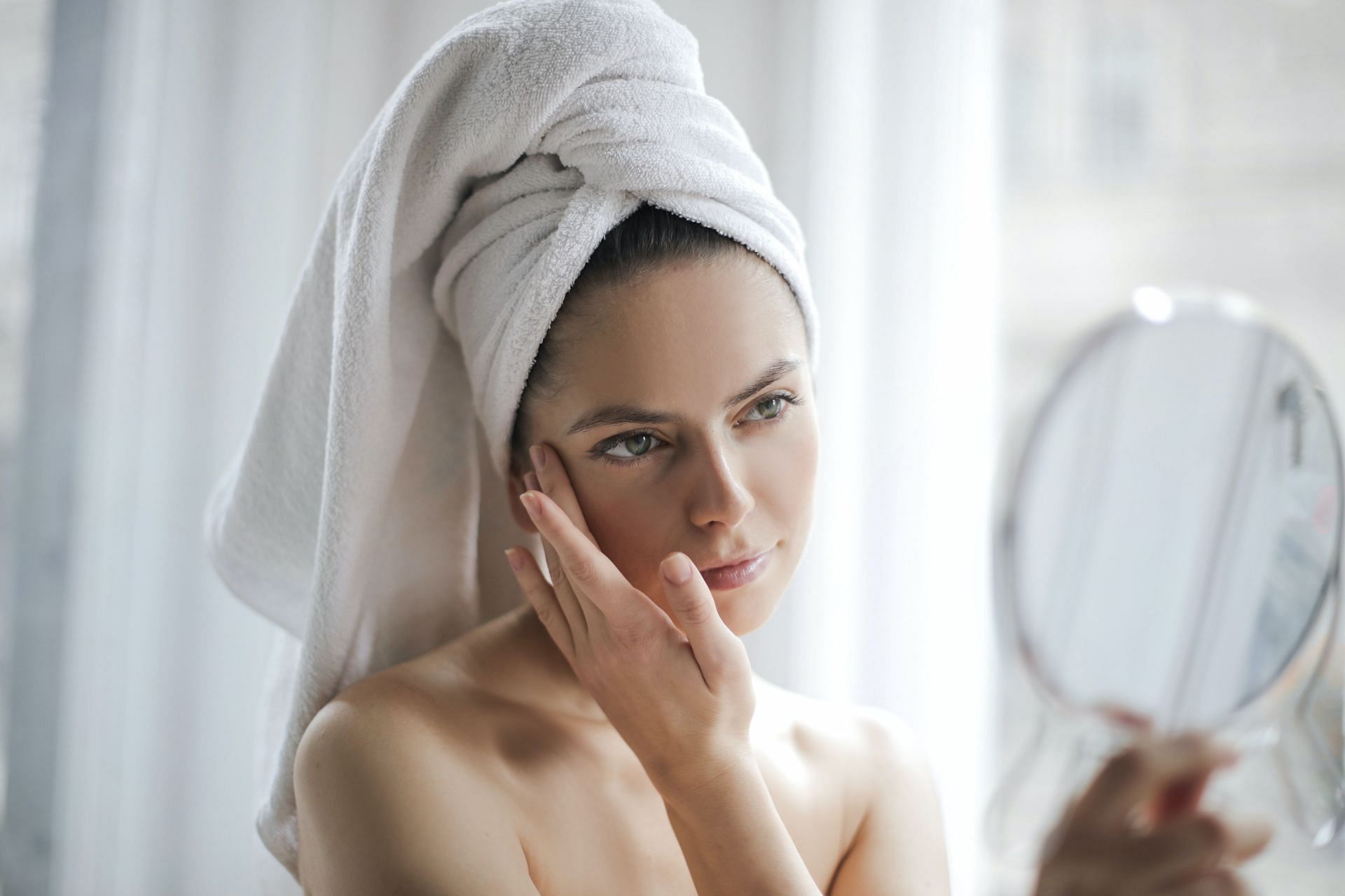 Woman seeing in a mirror. (Image via Pexels/Andrea Piacquadio)