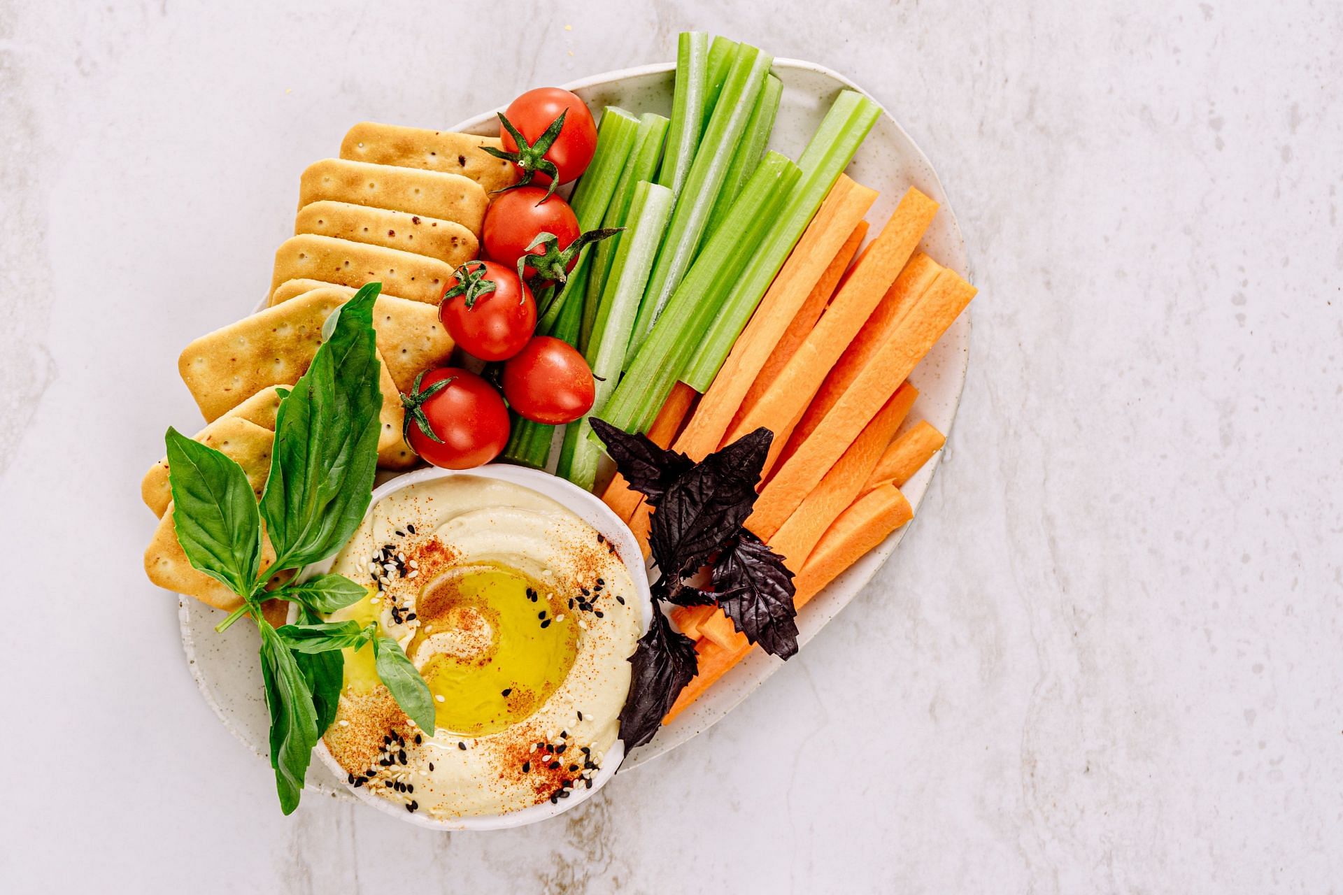 Wondering is hummus good for you? Make it healthier by pairing it with crunchy vegetables. (Image via Pexels/Antoni Shkraba)