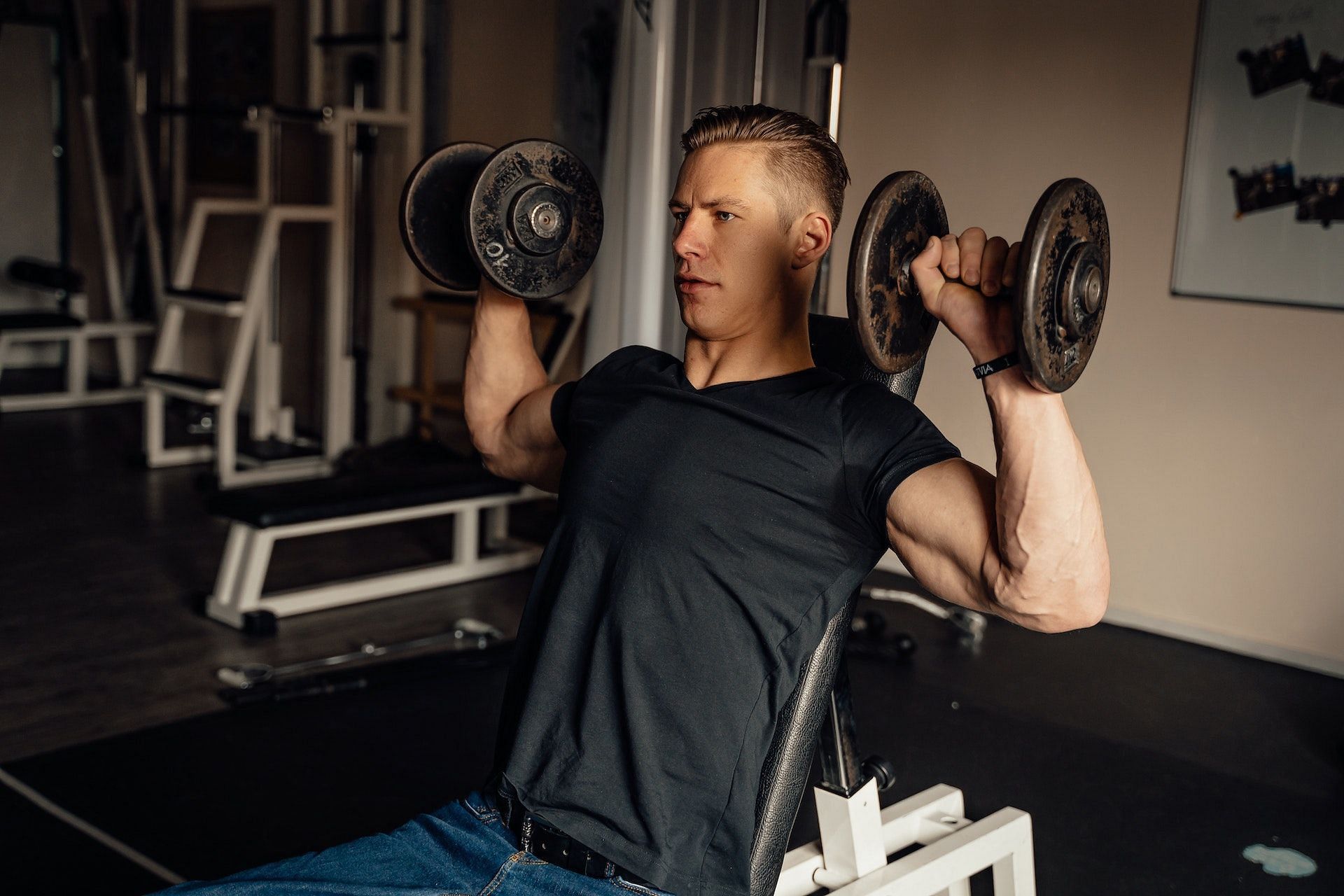 Seated dumbbell press is a great shoulder strengthening exercise. (Photo via Pexels/Alesia Kozik)