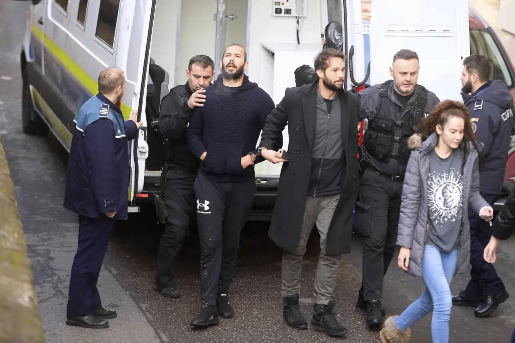 The Tate brothers and the other two suspects on their way to court on Wednesday (Image via Vadim Ghirda/AP)