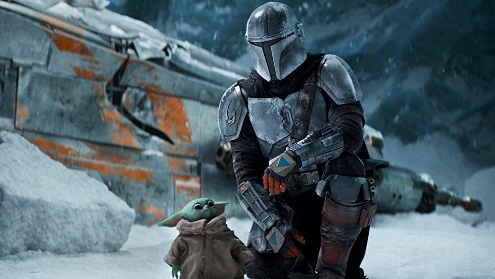 Mando escorts a frog-like alien and her eggs (Image via Lucasfilm)