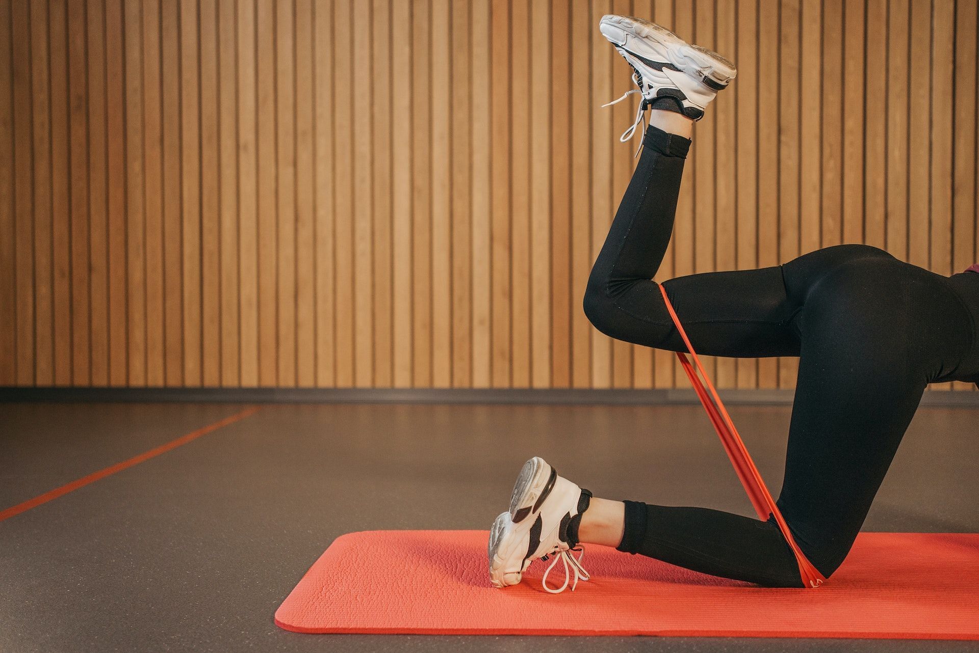 Resistance band kickbacks tone the hips, thighs, and hamstrings. (Photo via Pexels/Pavel Danilyuk)