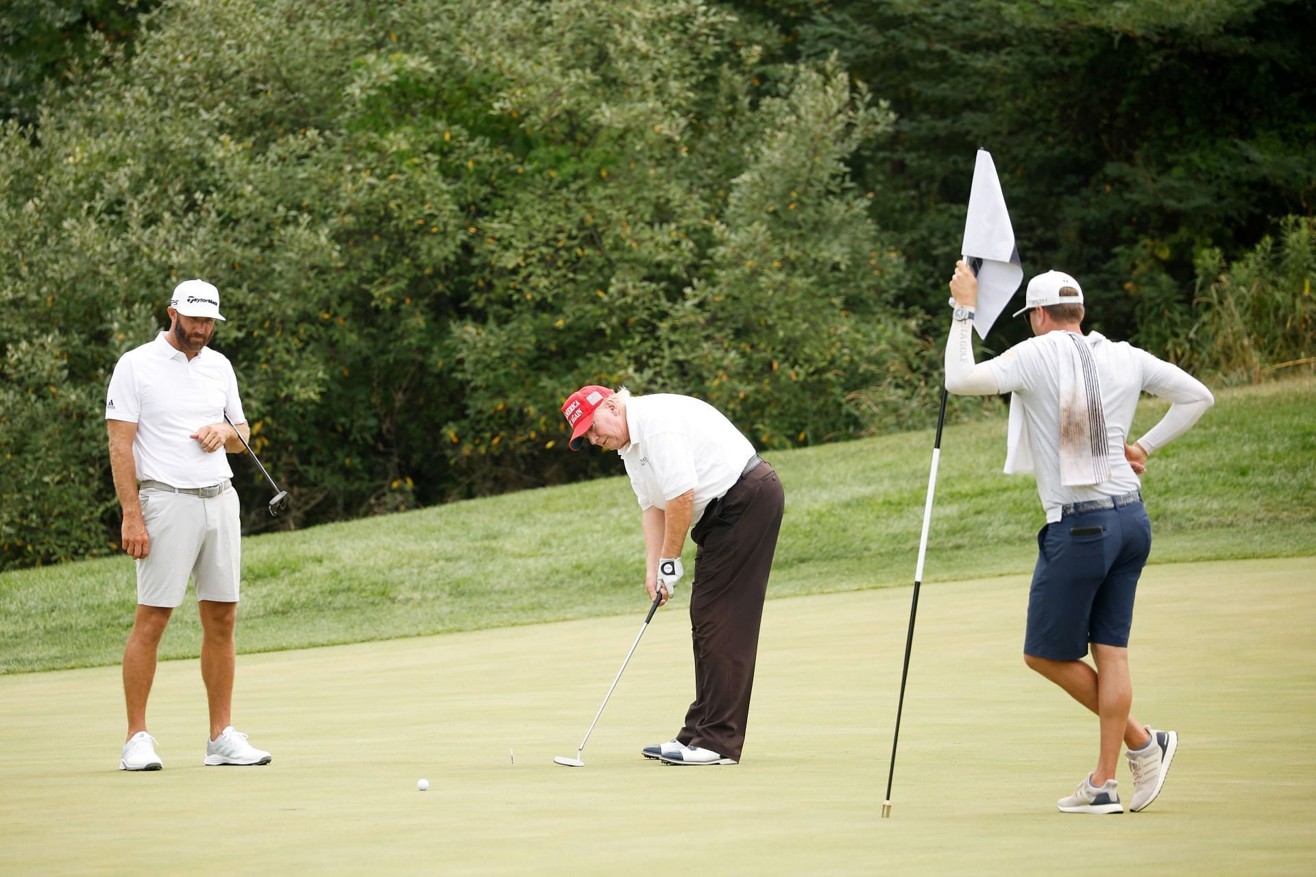 Donald Trump attempting a putt (Image via Cliff Hawkins/Getty Images)