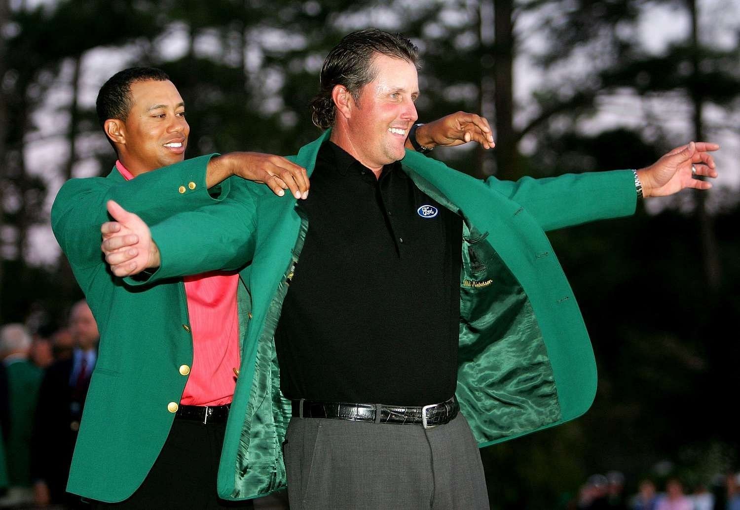 Tiger Woods helping Phil Mickelson wear his green jacket after his 2006 Masters win