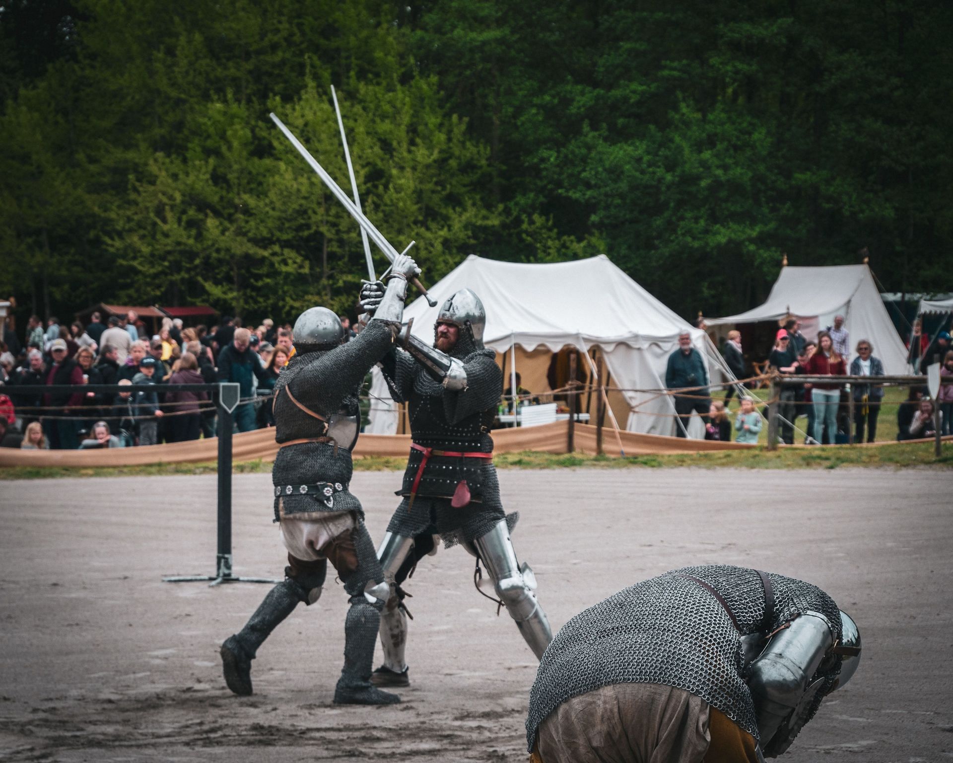 Knights combatting in a field. (Image via Unsplash/Casper Johansson)