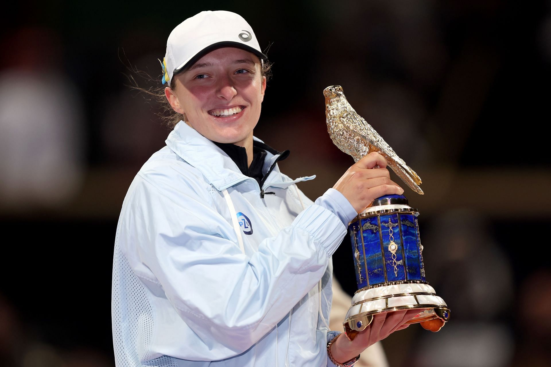 Iga Swiatek poses with her trophy after winning the 2023 Qatar Open