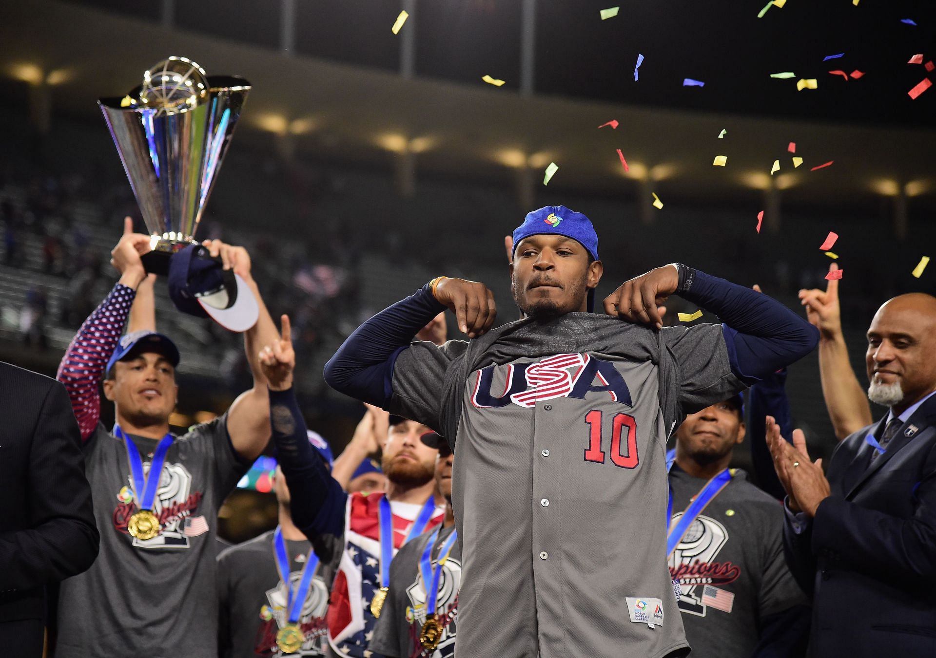 Adam Jones #10 of team United States shoes his USA shirt while teammate Giancarlo Stanton #27 holds the trophy after their 8-0 win over team Puerto Rico during Game 3 of the Championship Round of the 2017 World Baseball Classic at Dodger Stadium on March 22, 2017, in Los Angeles, California.