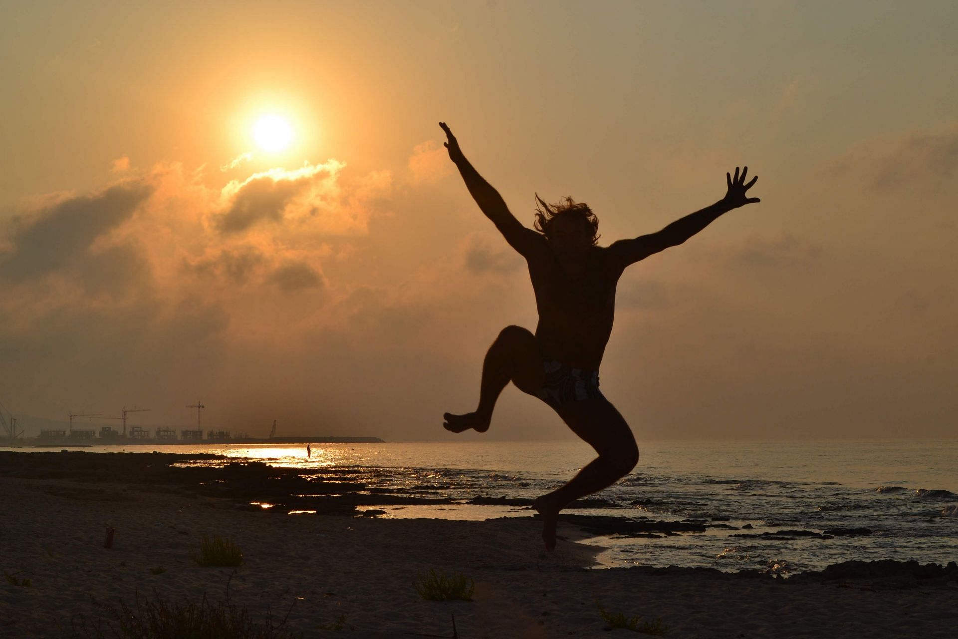 Silhouette of a person jumping in air. (Image via Unsplash/Eugene)