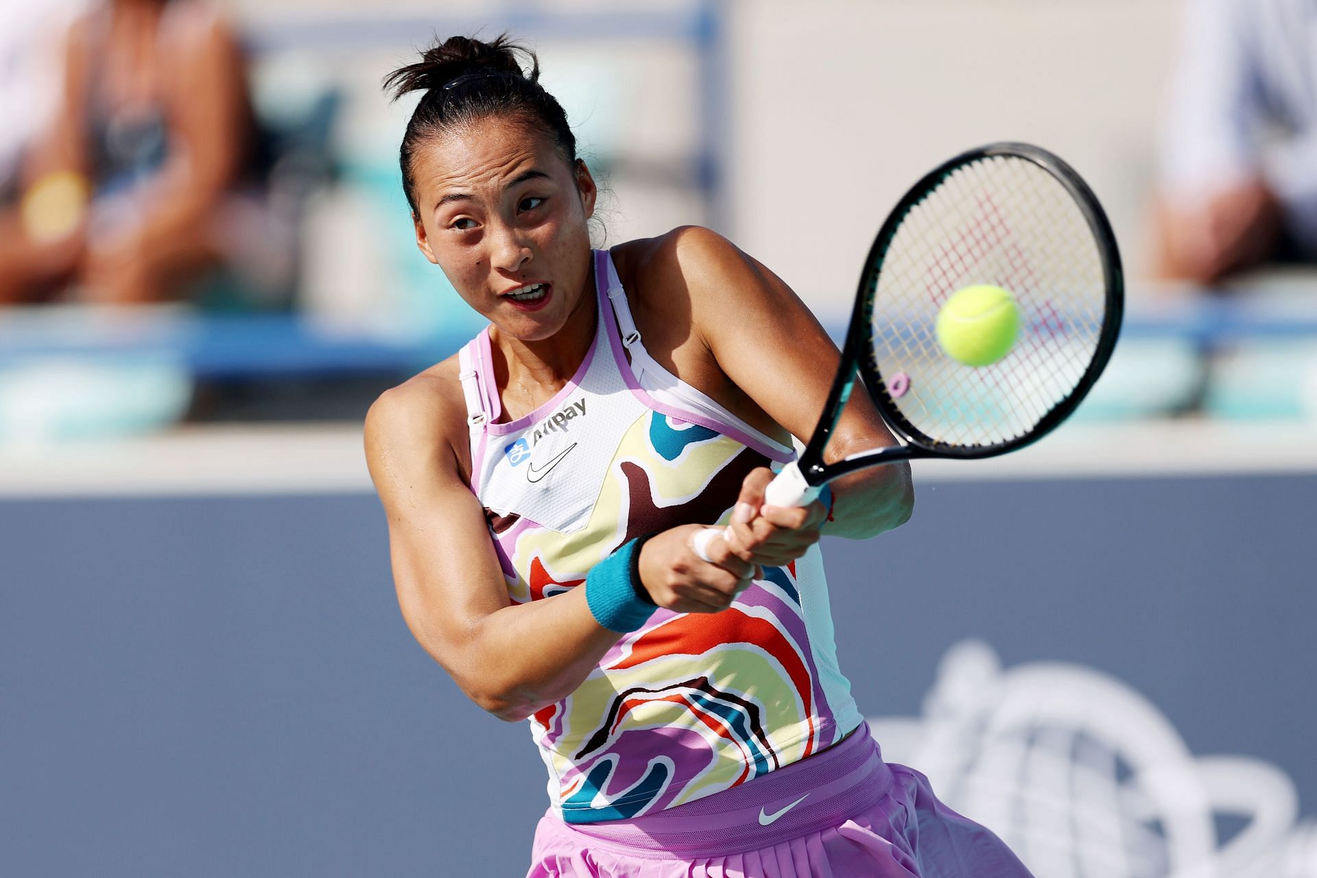 Qinwen Zheng strikes the ball at the Mubadala Abu Dhabi Open