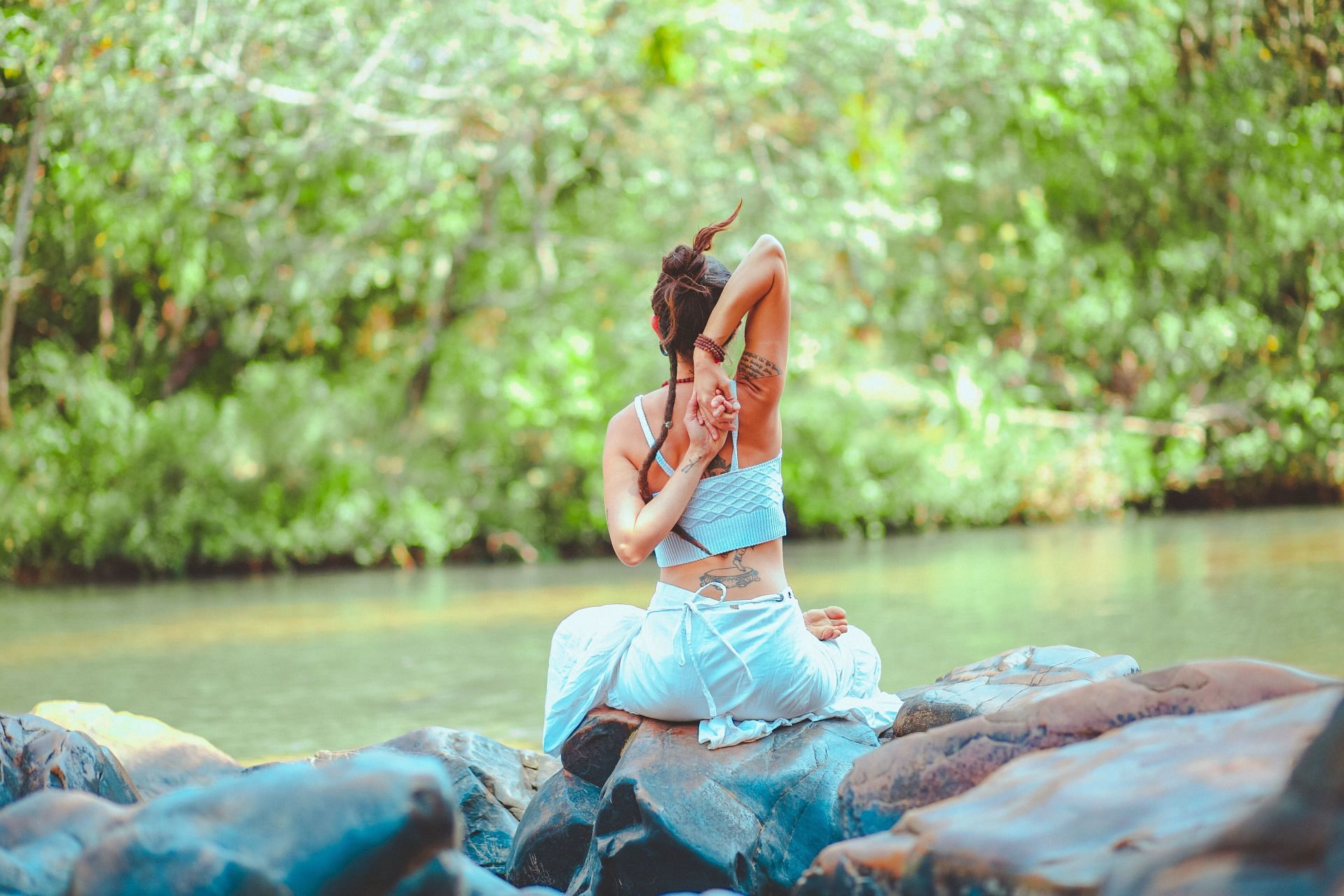 Woman performing yoga in outdoors. (Image via Pexels/ Lucas Pezeta)
