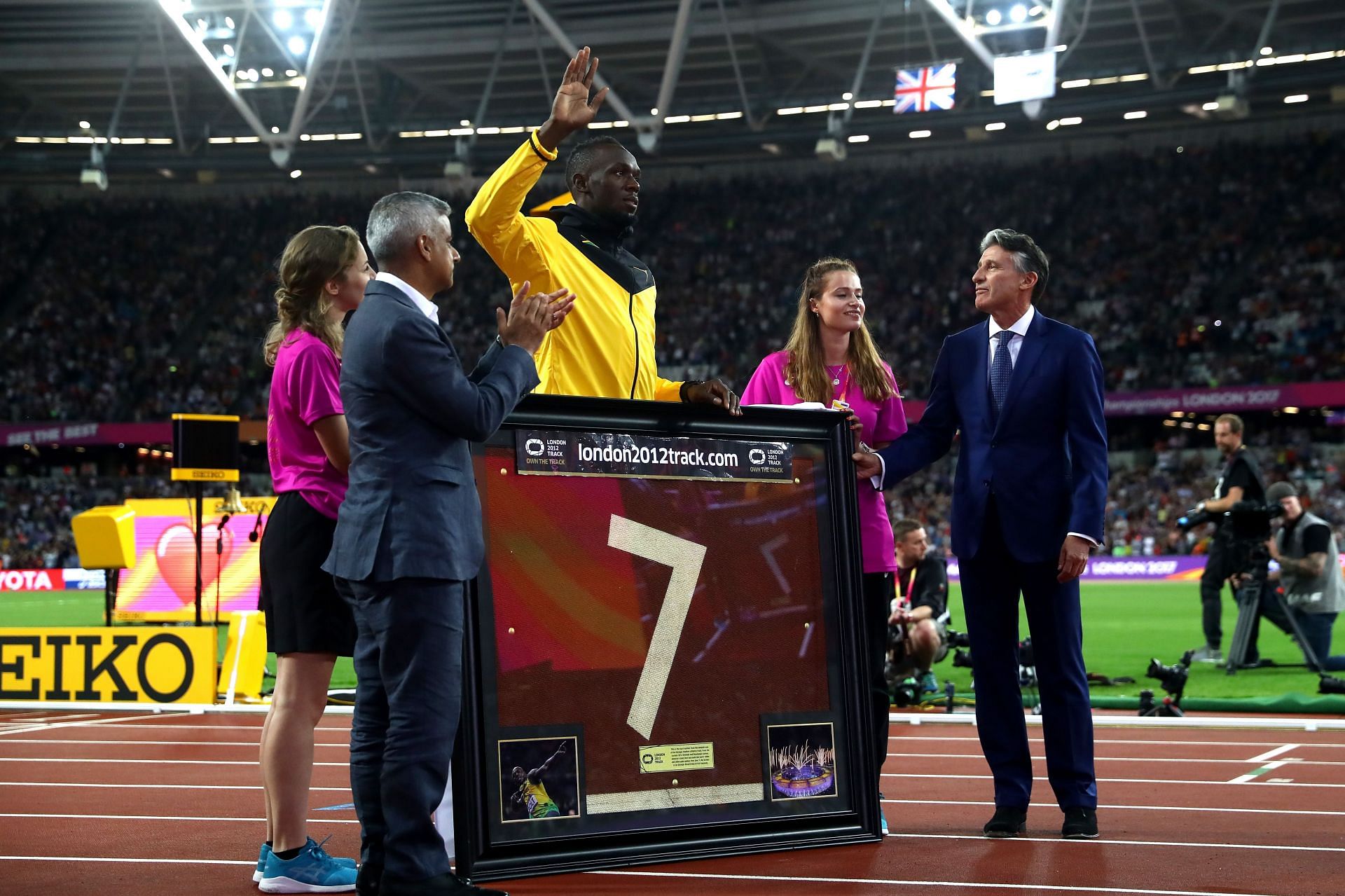 Usain Bolt of Jamaica is presented with a framed piece of the track during the 16th IAAF World Athletics Championships London 2017 