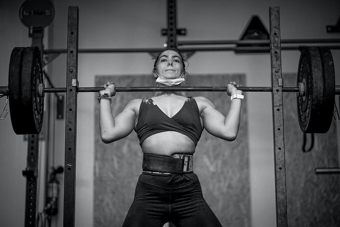 Standing shoulder press requires standing straight and taking the barbell above your head (ELIAS VICARIO/ Unsplash)