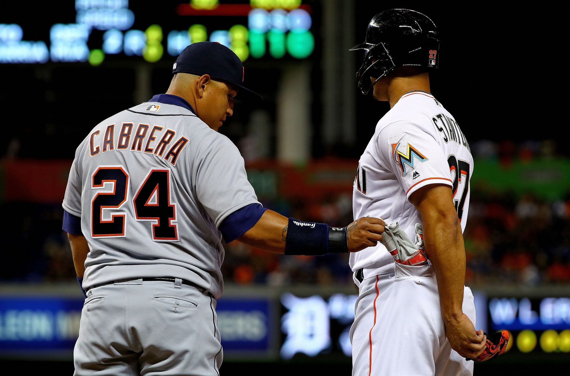 Miguel Cabrera #24 of the Detroit Tigers steals a batting glove from the pocket of Giancarlo Stanton #27 of the Miami Marlins