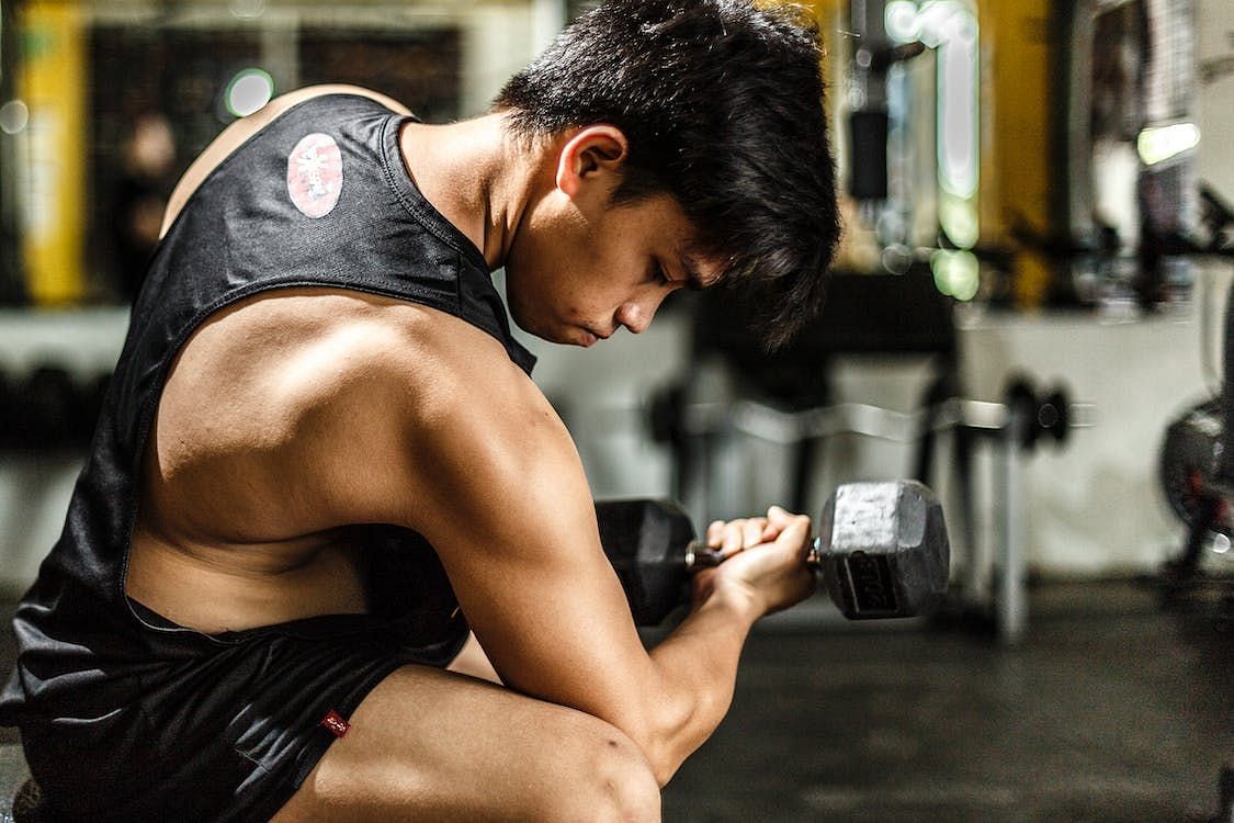 Dumbbell workouts can be done at home or in the gym. (Image via Pexels/Timothy)