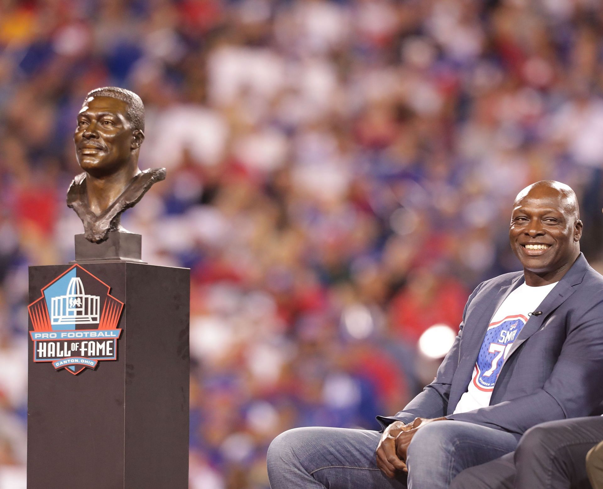 Hall of Famer Bruce Smith is pictured with his statue during halftime in a game between Buffalo Bills and New York Jet