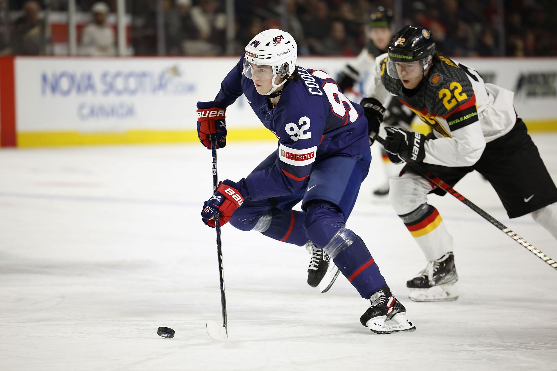 Logan Cooley #92 of Team USA skates the puck ahead of Philipp Bidoul #22 of Team Germany in the second period in a quarterfinal game of the 2023 IIHF World Junior Championship at Avenir Centre on January 2, 2023 in Moncton, Canada. (Photo by Dale Preston/Getty Images)