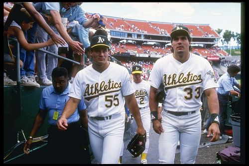 Oakland Athletics: 1990: Outfielder Jose of the Oakland Athletics (right) walks with his brother and teammate Ozzie Canseco. Mandatory Credit: Otto Greule Allsport