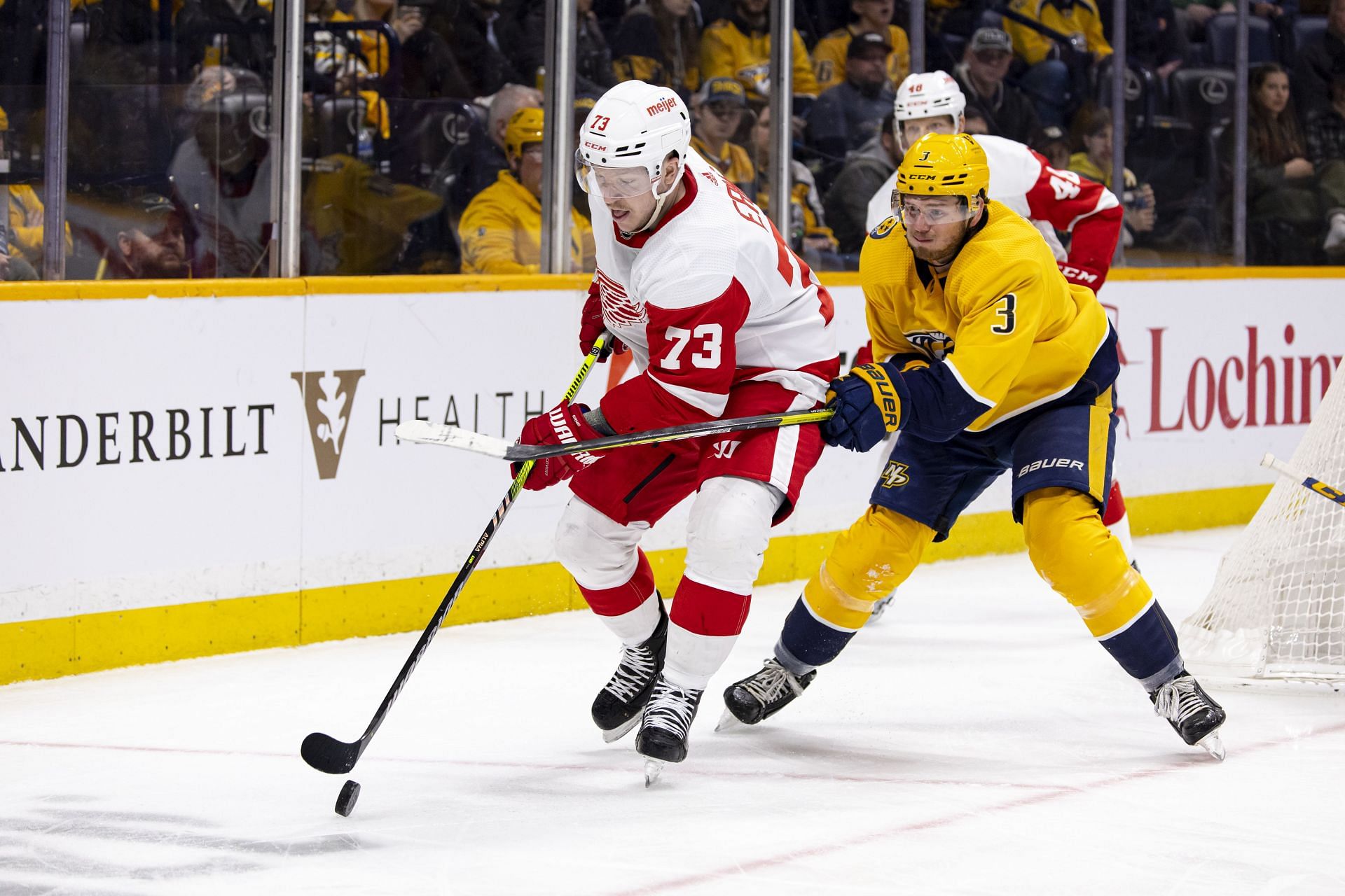 Adam Erne #73 controls the puck against Jeremy Lauzon #3 of the Nashville Predators