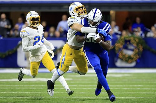  Jelani Woods #80 of the Indianapolis Colts tackled by Drue Tranquill #49 of the Los Angeles Chargers