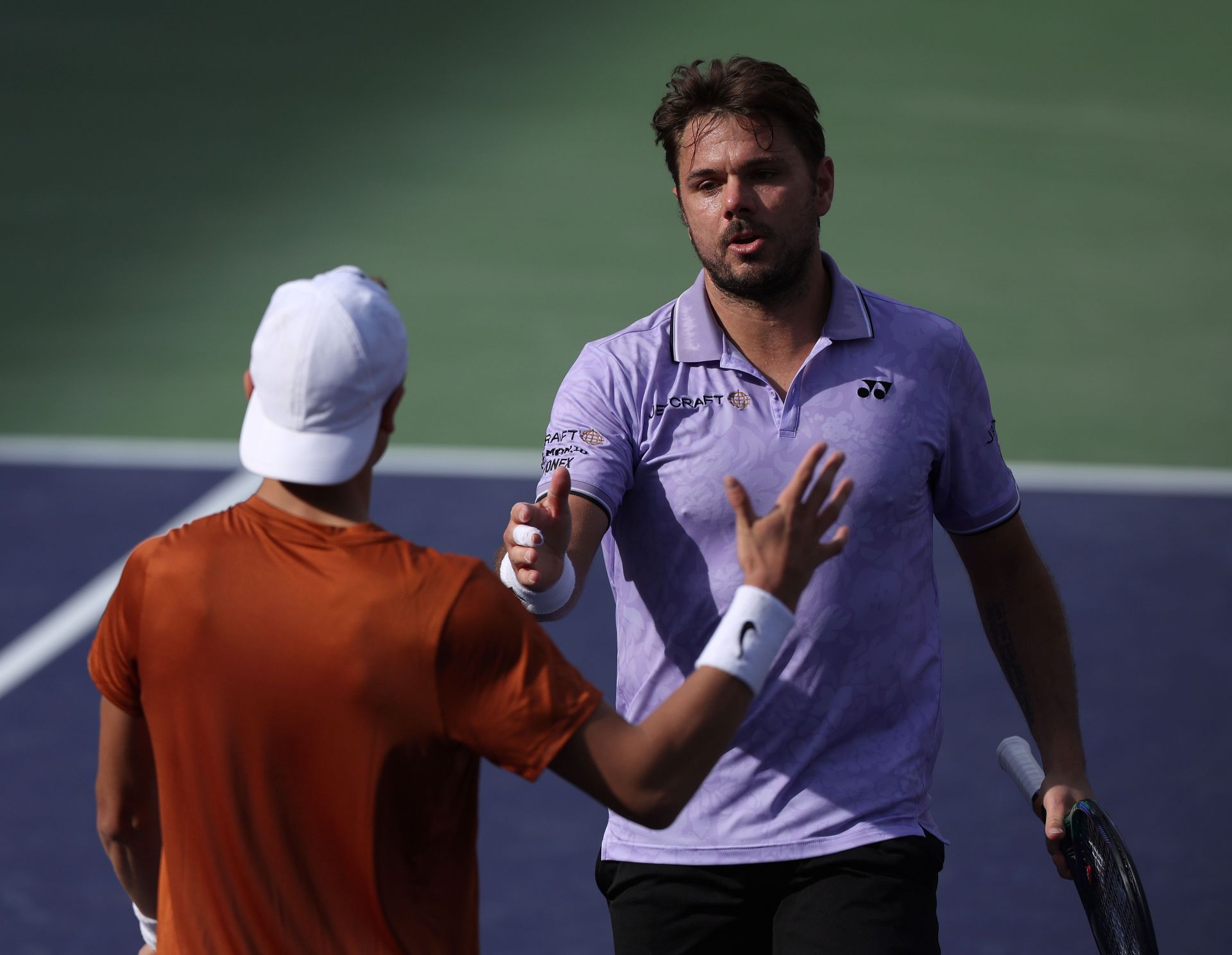 Stan Wawrinka meets Holger Rune at the net after their match at 2023 Indian Wells.