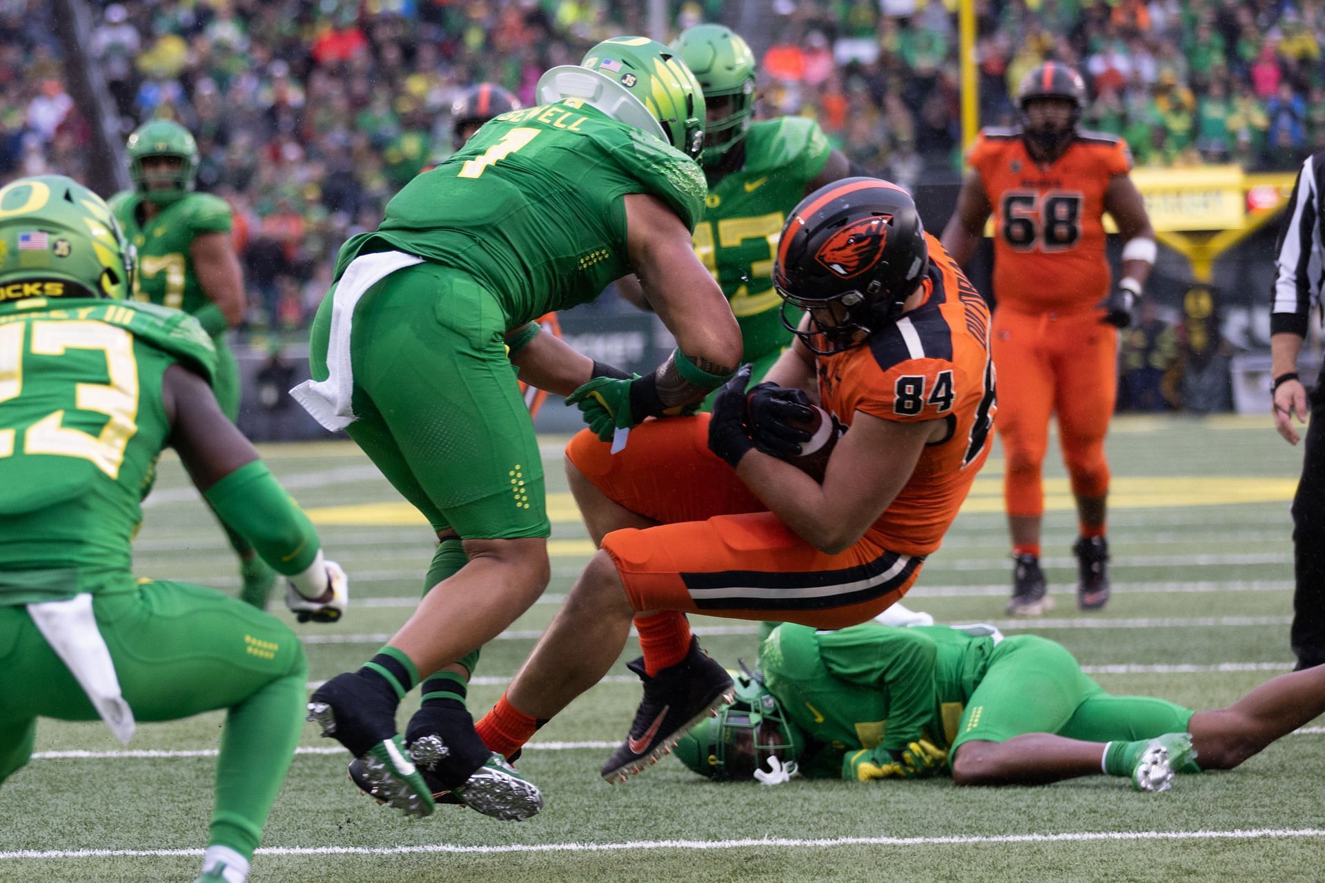 Noah Sewell #1 of the Oregon Ducks hits Teagan Quitoriano #84 of the Oregon State Beavers