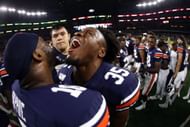 Zakoby McClain #35 and Owen Pappoe #10 of the Auburn Tigers celebrate a 27-21 win against the Oregon Ducks