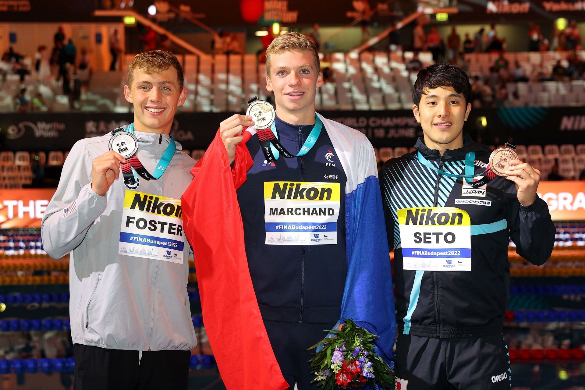 Carson Foster (Silver medalist), Leon Marchand (Gold medalist), and Daiya Seto (Bronze Medalist) pose after the Men&#039;s 200m Individual Medley at the Budapest 2022 FINA World Championships.