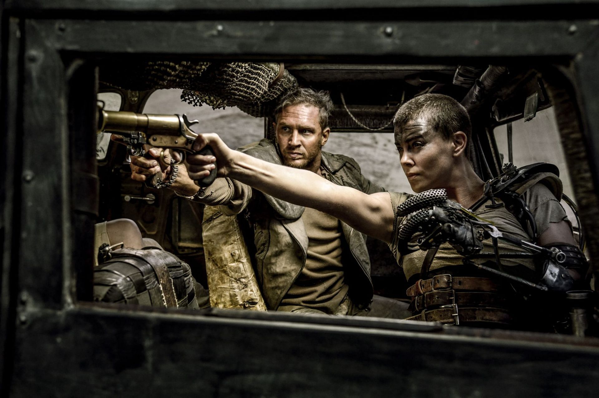 A high-octane, post-apocalyptic road trip through a world gone mad with Charlize Theron and Tom Hardy leading the way (Image via Warner Bros)