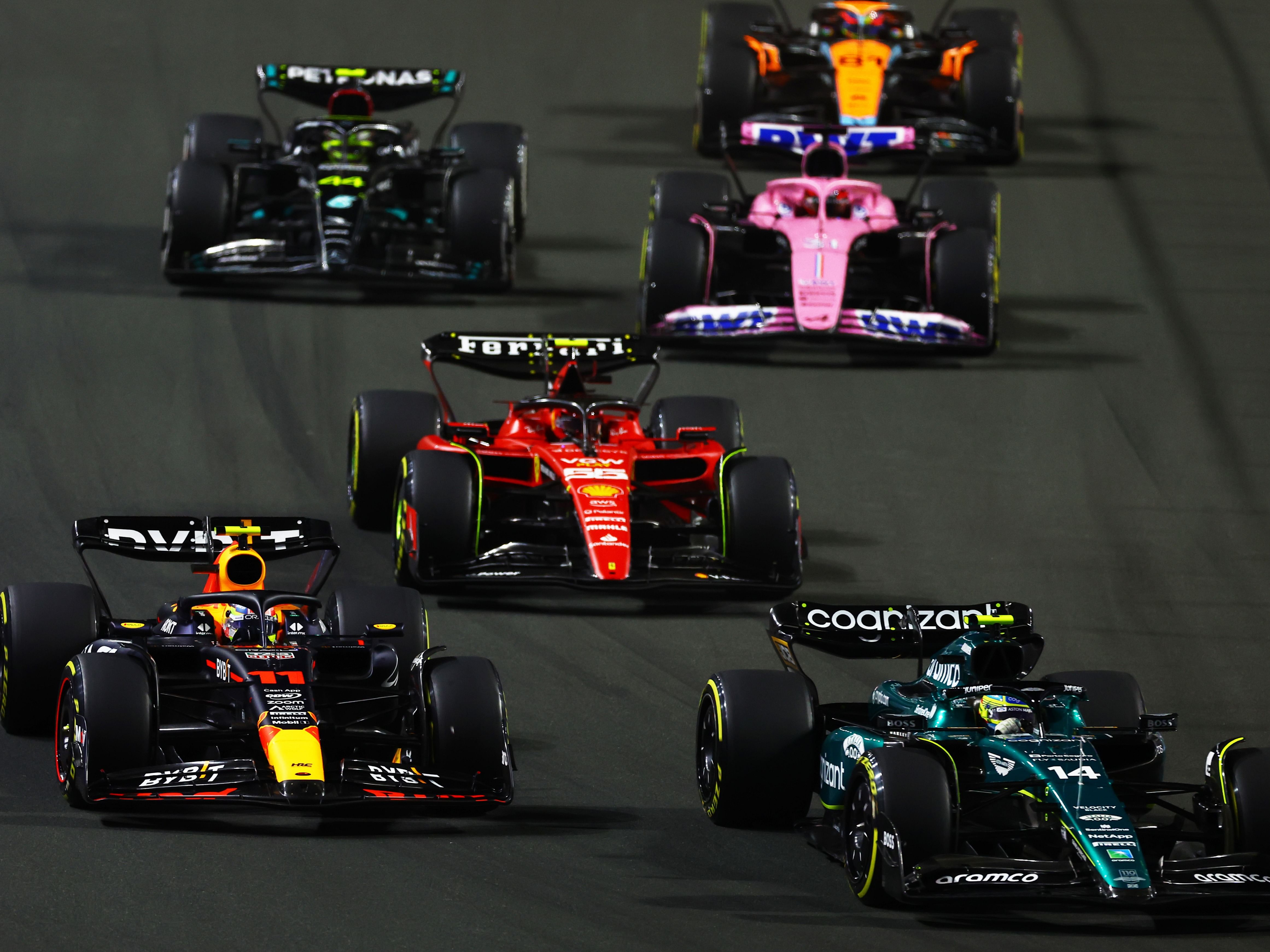 Fernando Alonso (14) leads Sergio Perez (11) and the rest of the field into turn one at the start of the 2023 F1 Saudi Arabian Grand Prix (Photo by Mark Thompson/Getty Images)