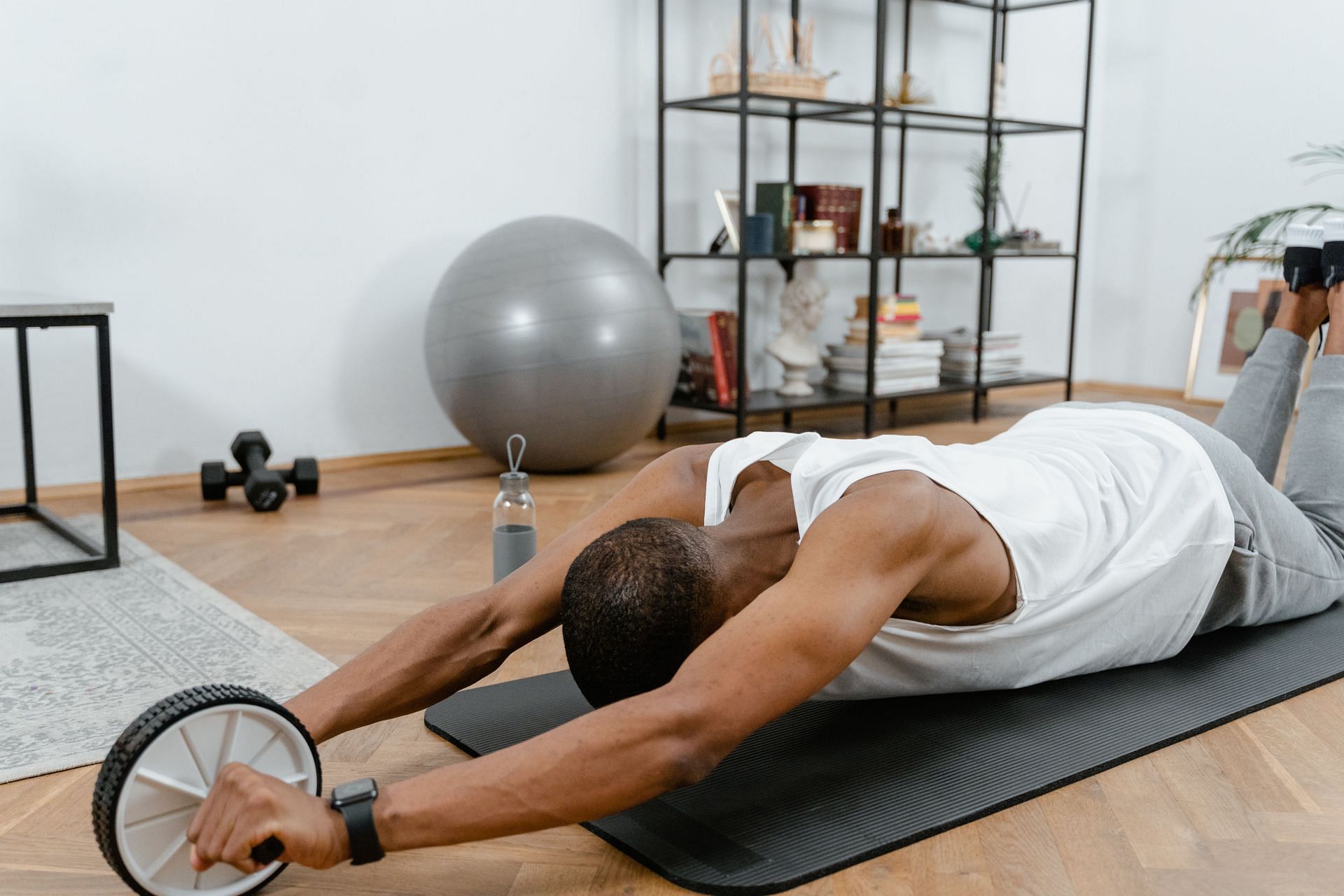 Keep your back straight while performing ab roller exercises. (Image via Pexels/Mart Production)