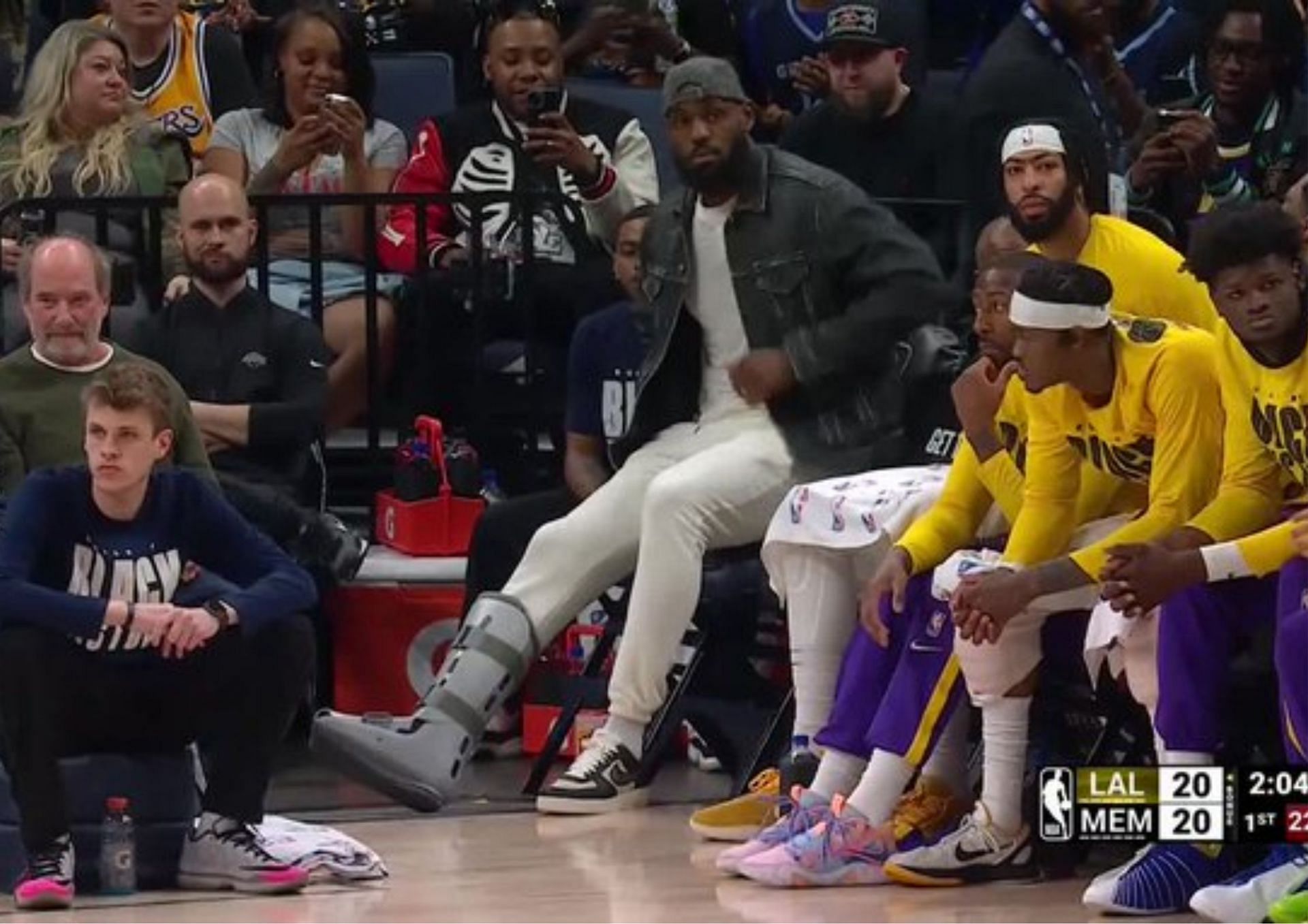 LeBron James wearing a boot on his injured right foot while watching the LA Lakers in action. [photo: FanSided]