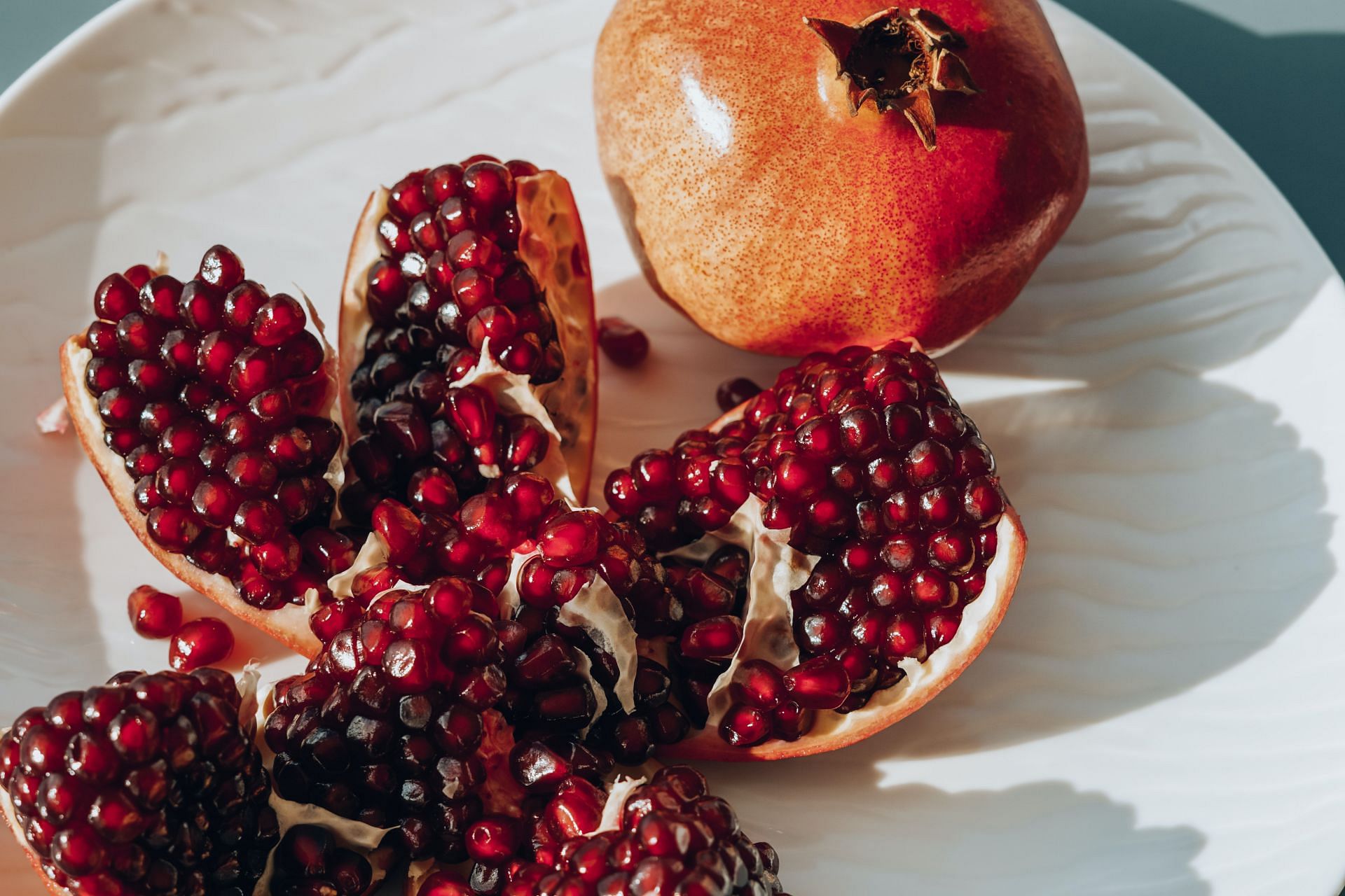 The juicy, ruby-red arils of pomegranate burst with health benefits (Image via Pexels)