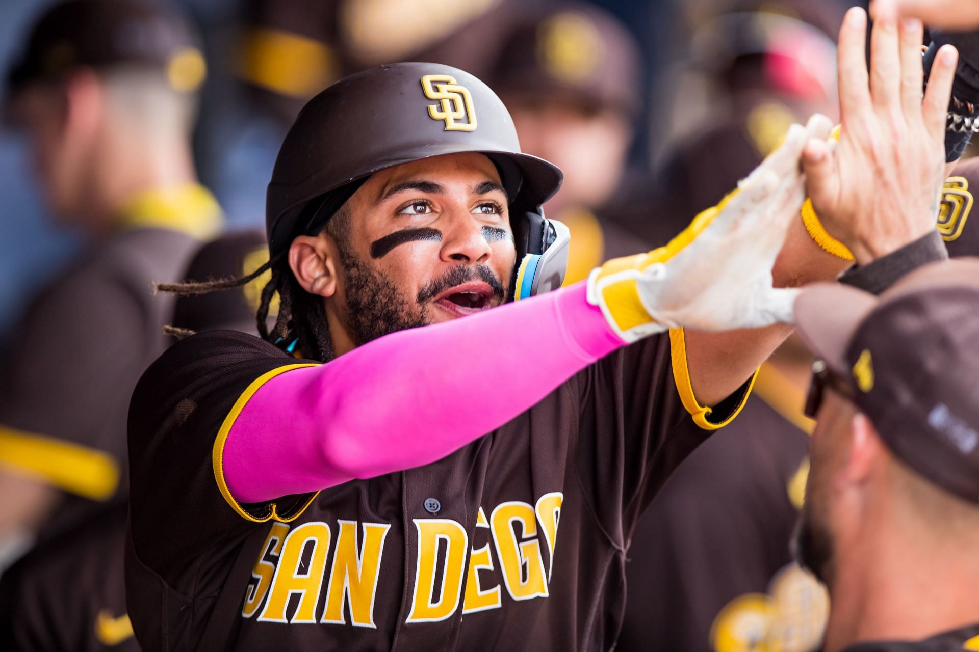 Fernando Tatis Jr. of the San Diego Padres high-fives teammates.